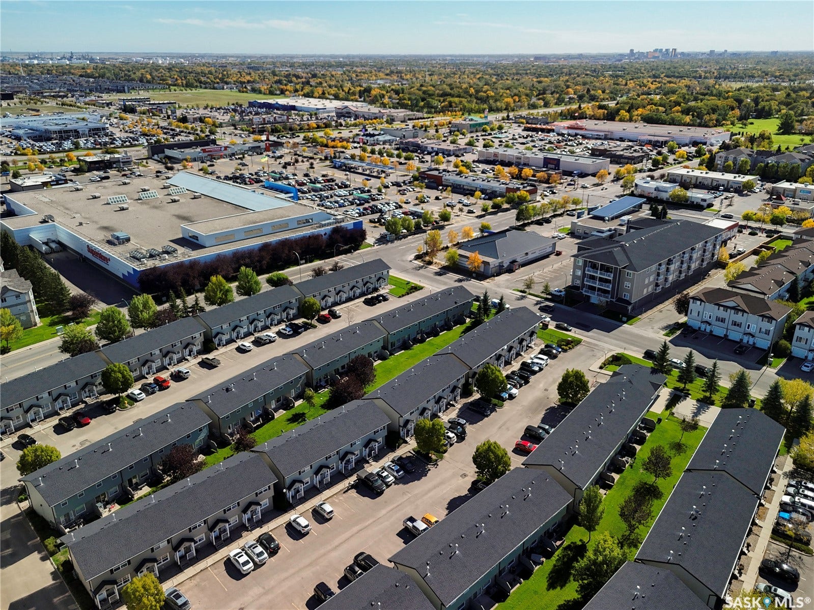 Aerial view showcasing a modern industrial complex featuring multiple warehouse and distribution buildings with contemporary dark-finish roofing, organized parking areas, and mature landscaping throughout the property