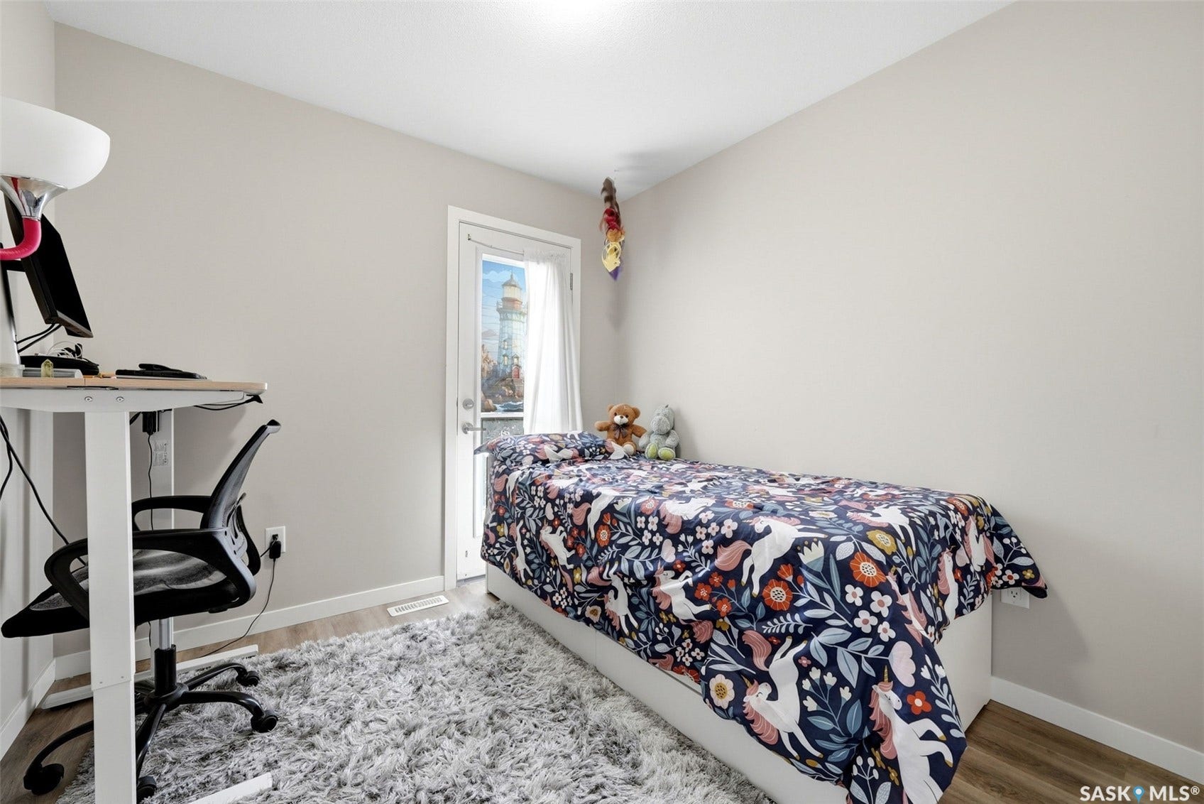 Neutral wall color, wood-finish flooring, and a single door leading to an exterior space
