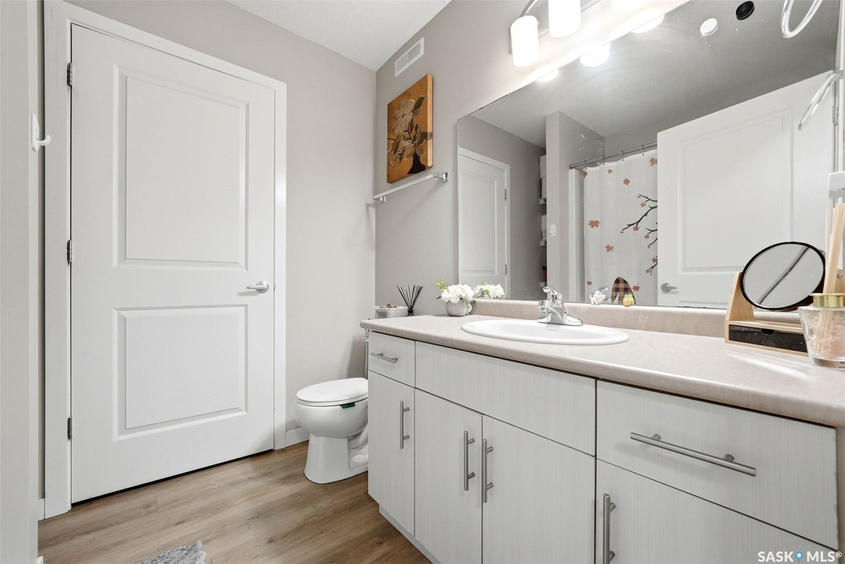 Spacious vanity with an integrated sink, brushed nickel hardware, and wood-finish flooring