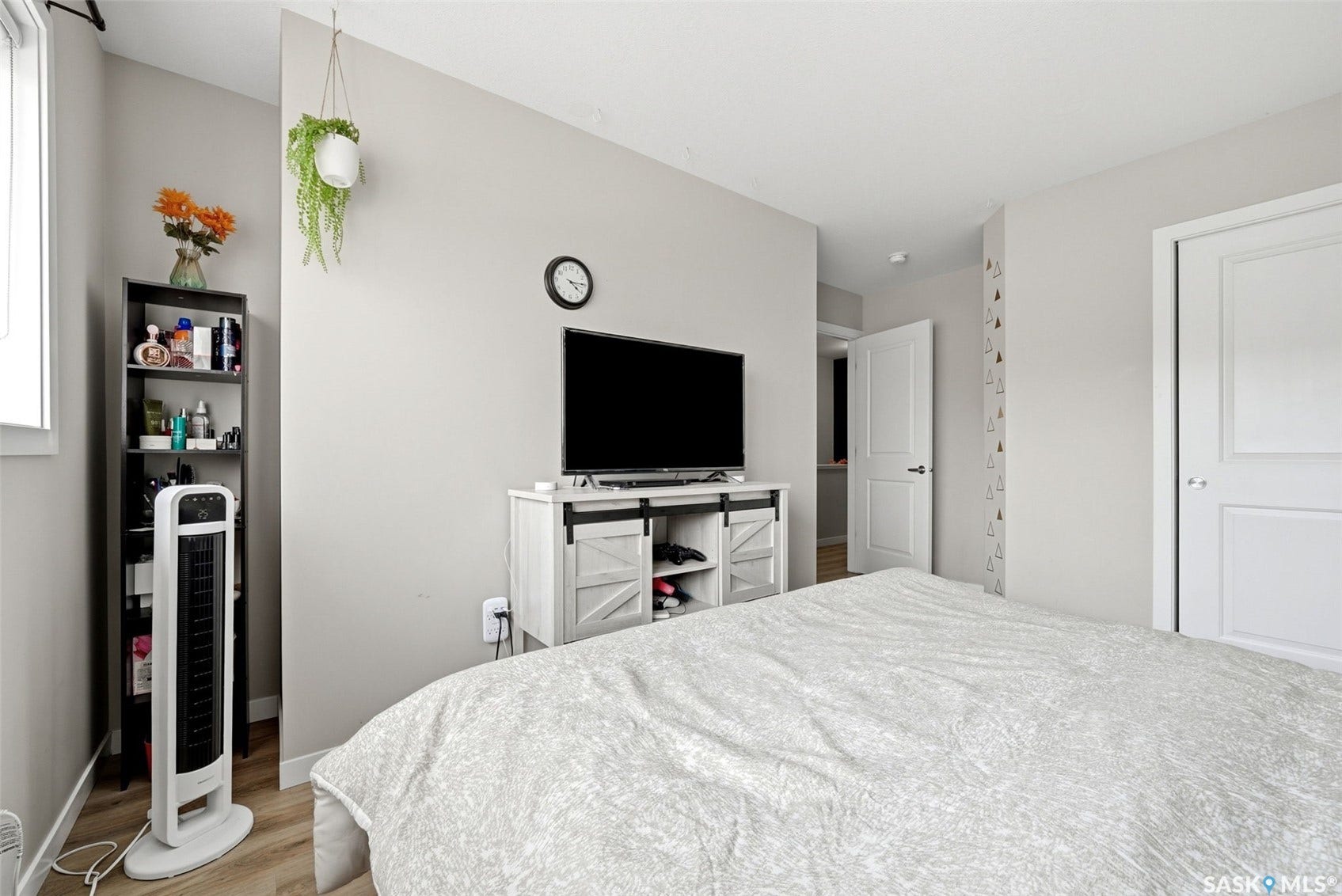 Light-toned walls, wood-finish flooring, and white paneled doors