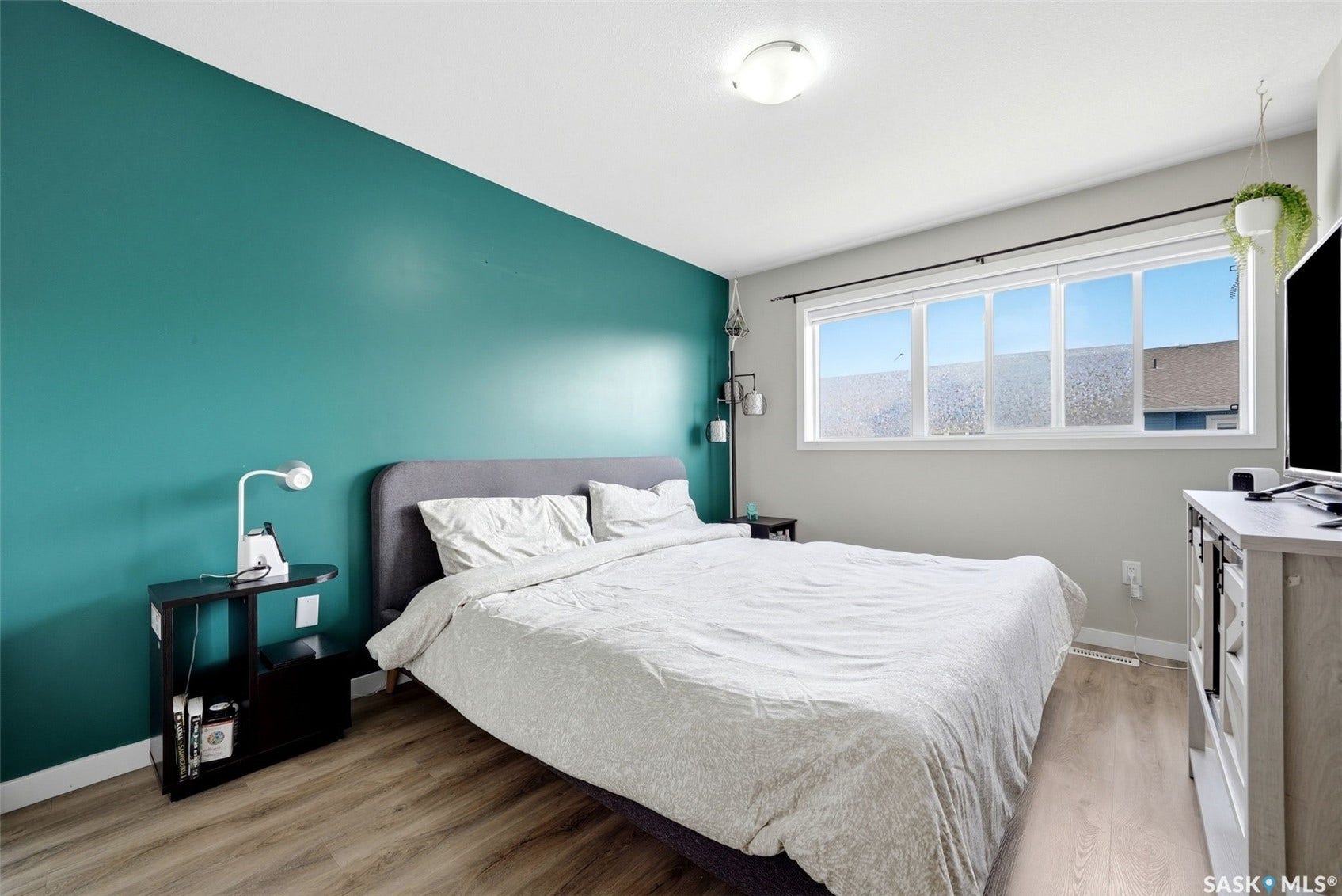 Wood-finish flooring, accent wall, multi-pane window, flush-mount ceiling light