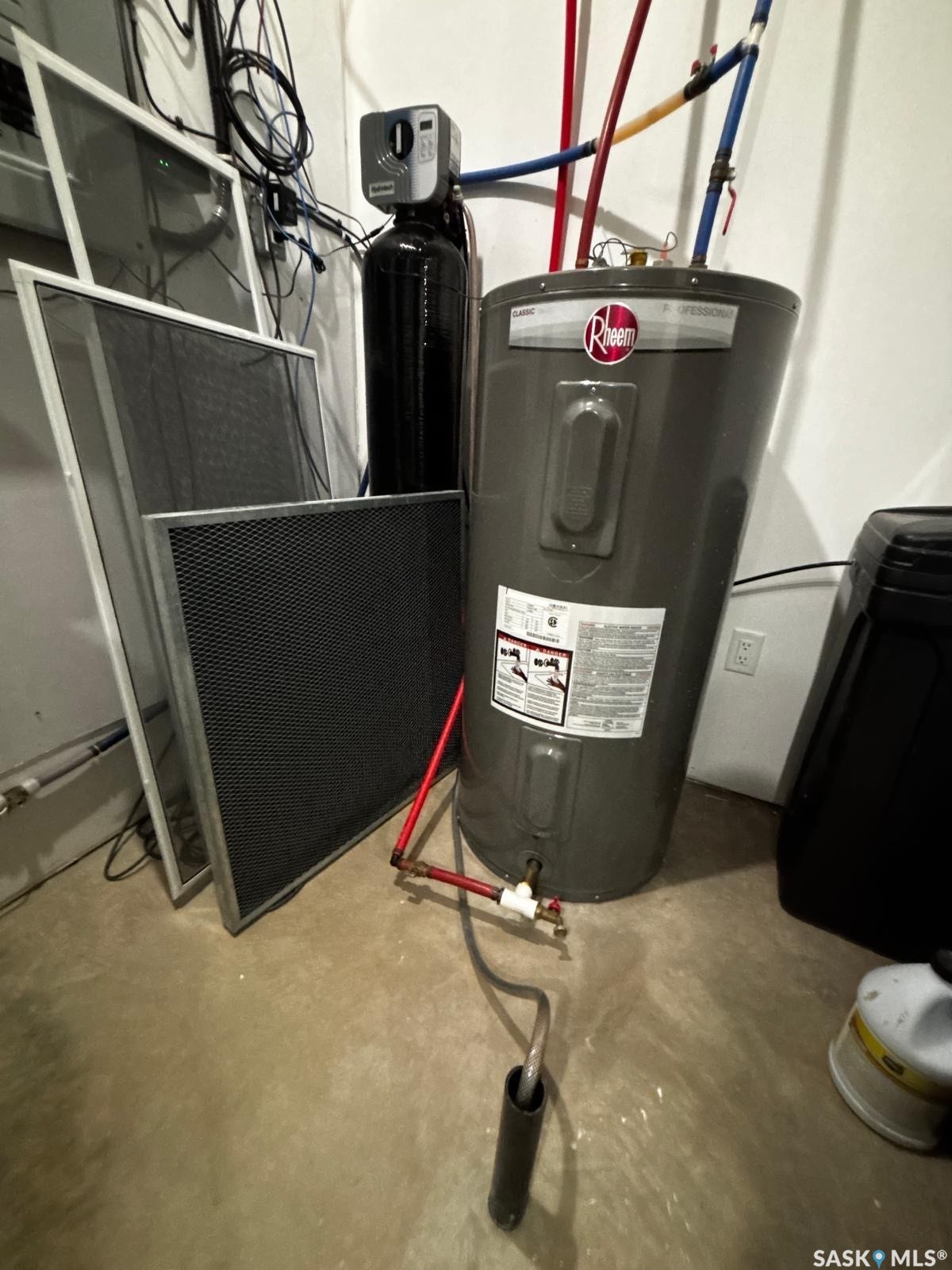 Water heater with visible plumbing, accompanied by a water conditioning system