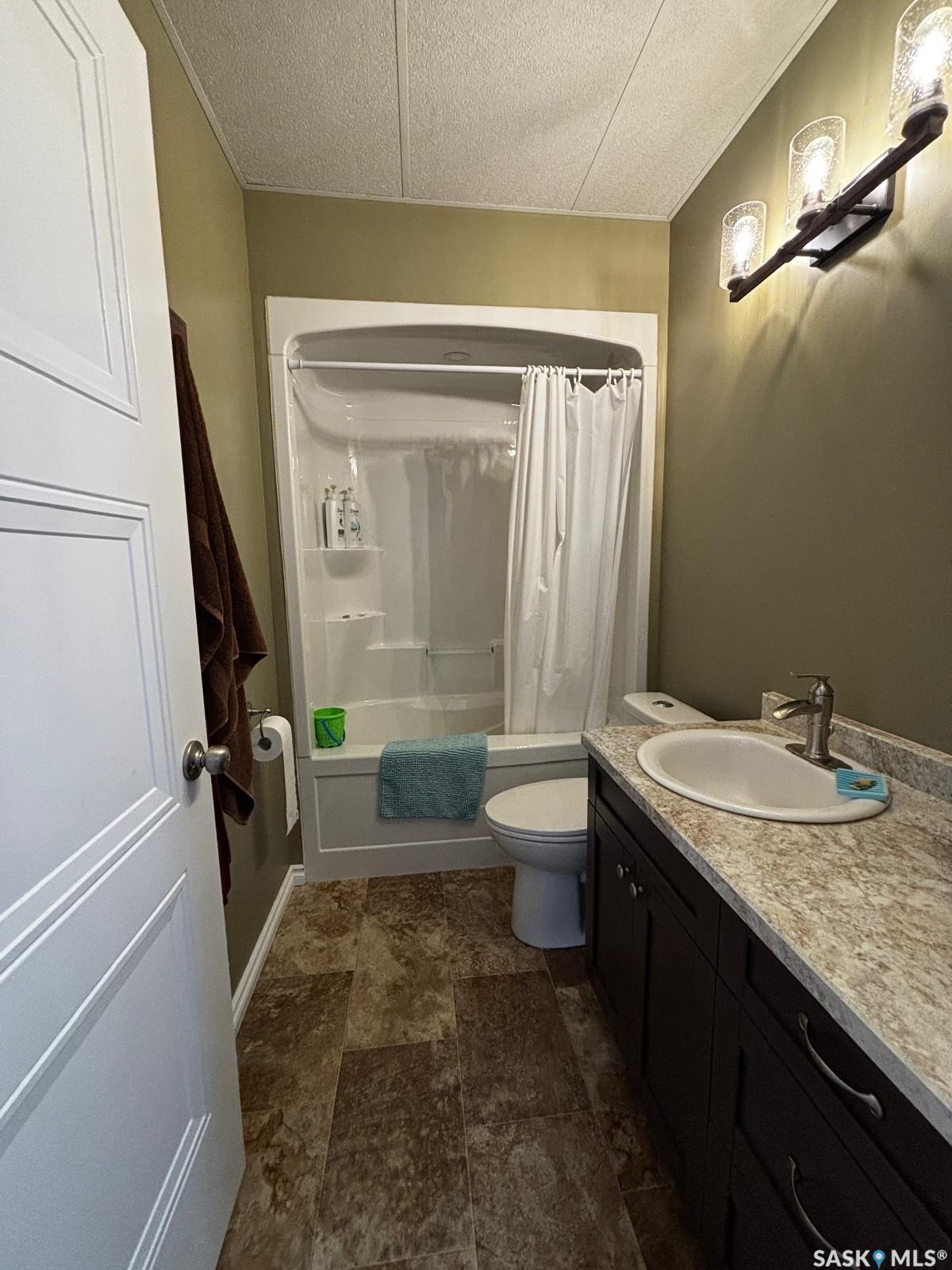 Dark wood-finish vanity with an oval basin sink, a light-toned countertop, and chrome faucet