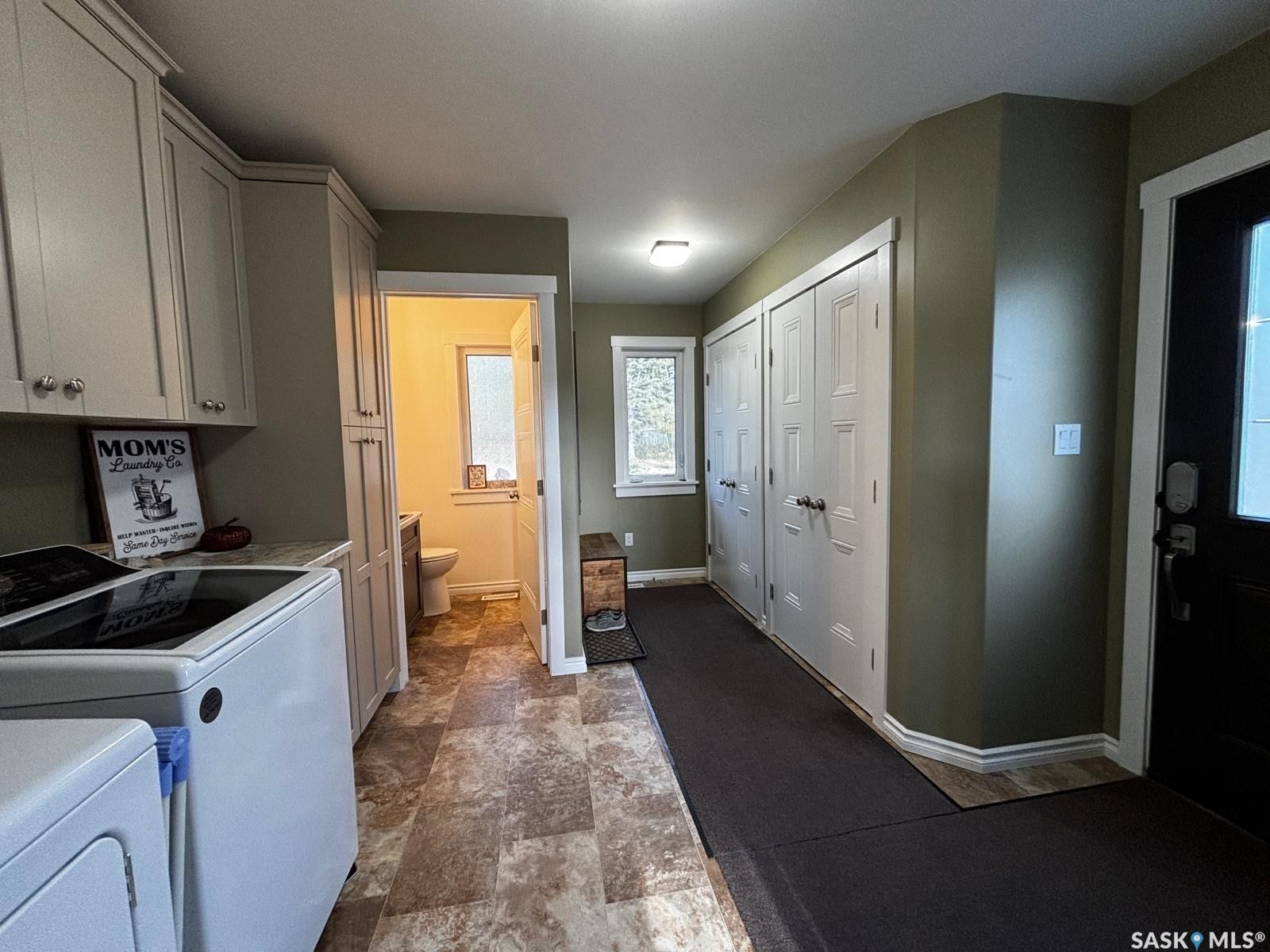 Laundry and Mudroom with Built-in cabinetry with silver hardware, full-height storage, and a light-toned countertop