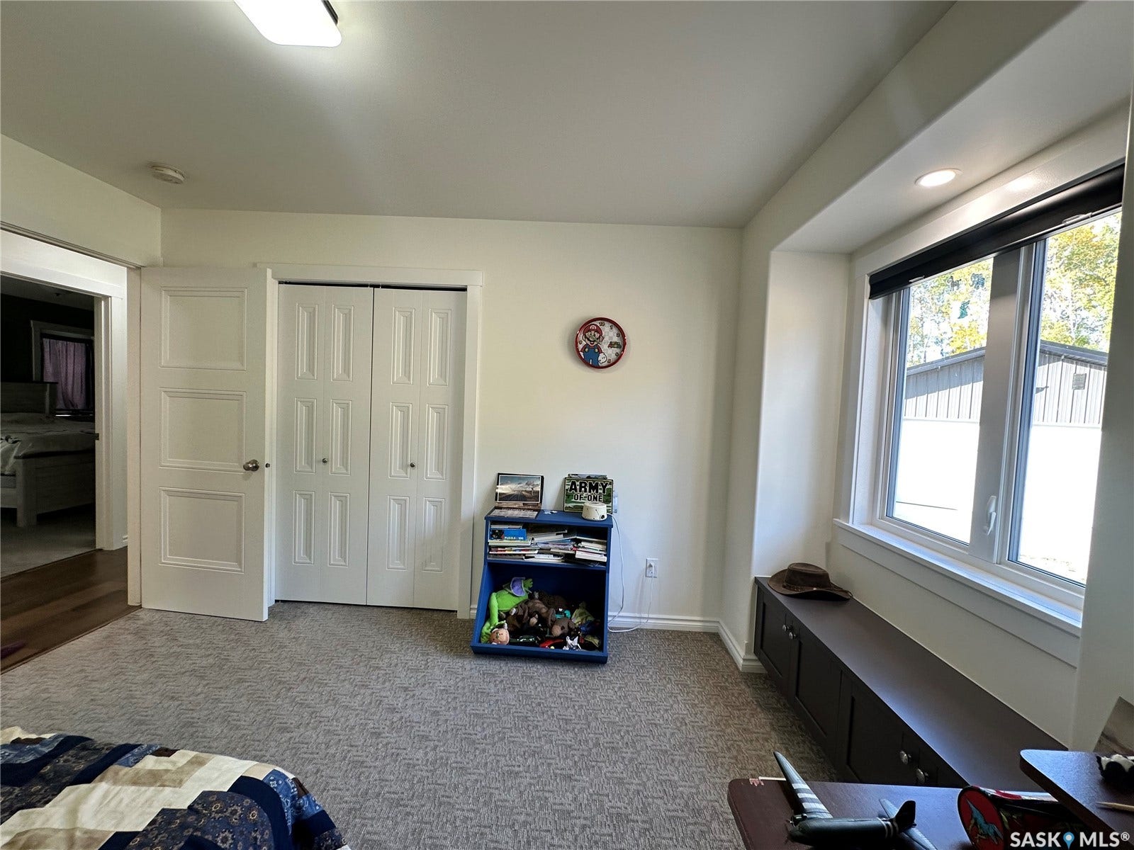 Carpeted flooring, built-in storage bench, recessed lighting, white panel doors, and a window with a roller shade