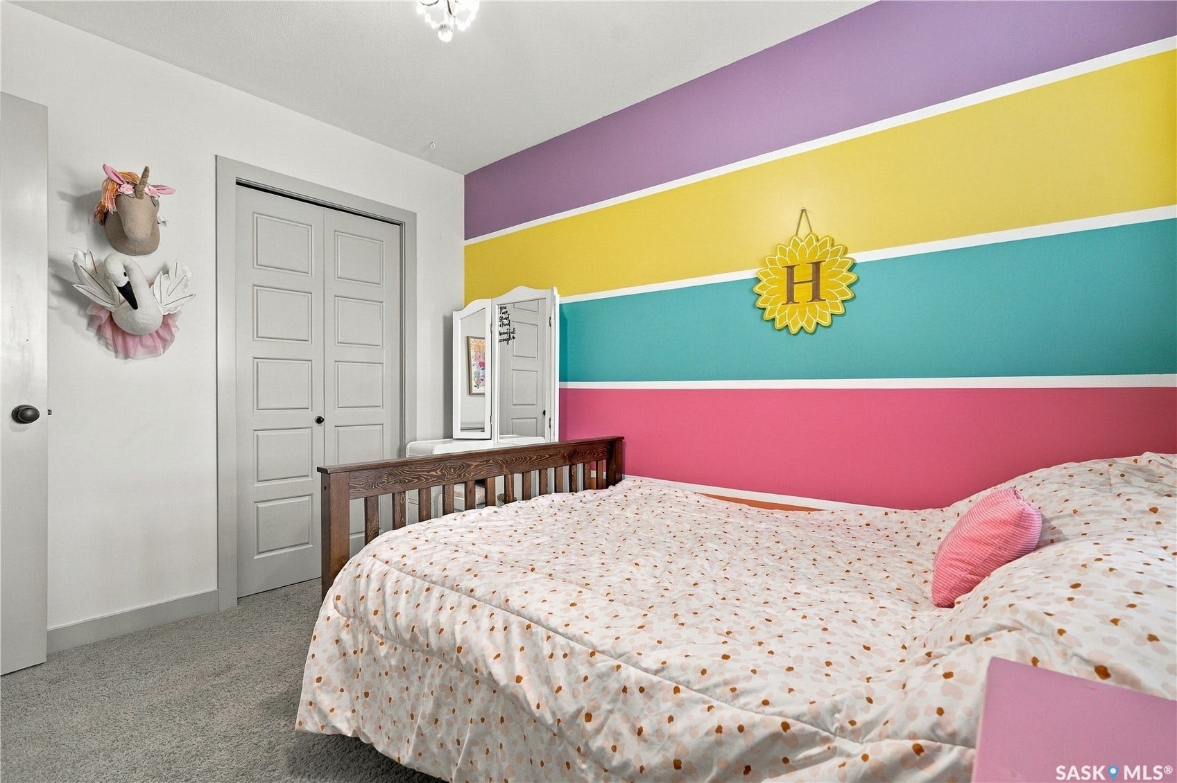 2nd floor bedroom with colorful accent wall and carpet flooring