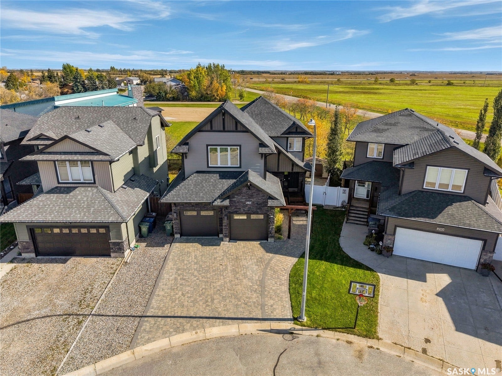 Exterior featuring multiple gables, stone accents, and a paved driveway