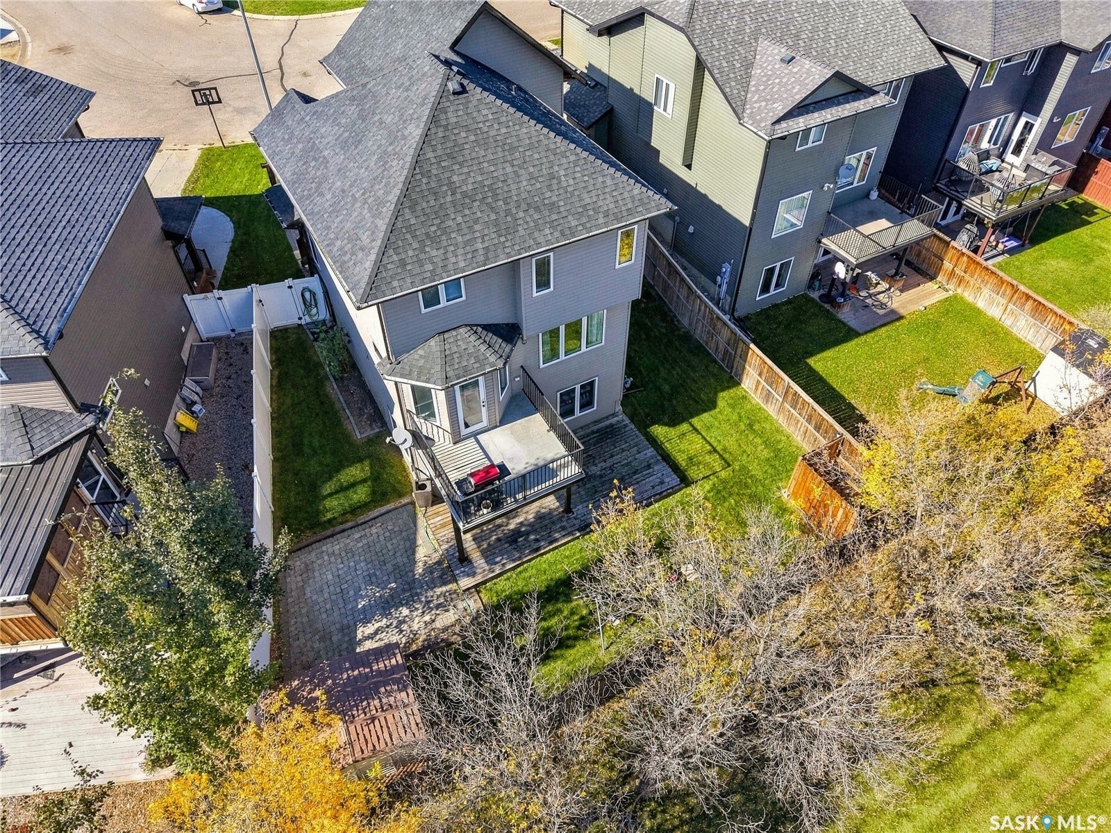 Contemporary residential property with a multi-level deck, fenced backyard, and mature trees