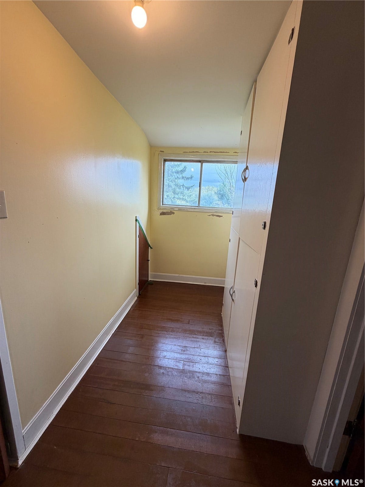Wood-finish flooring with built-in cabinetry and natural light