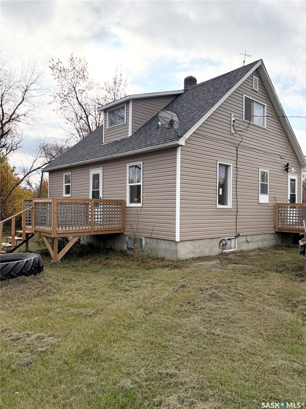 Tan siding exterior with a dark shingle roof