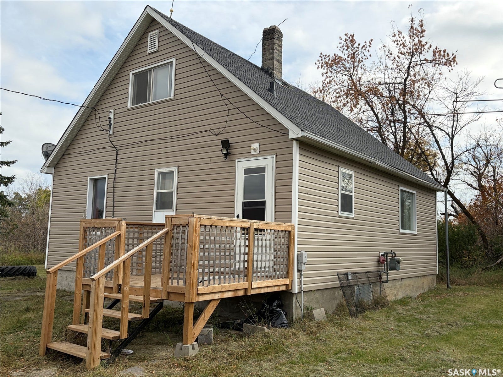 Two-story residence featuring light brown siding and a dark shingle roof