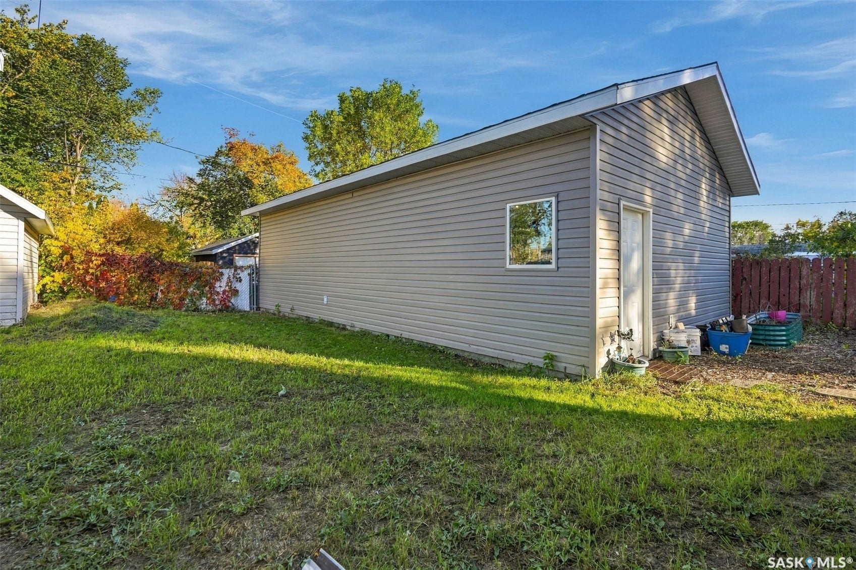 Detached structure with horizontal siding, a side entry door, and a single window