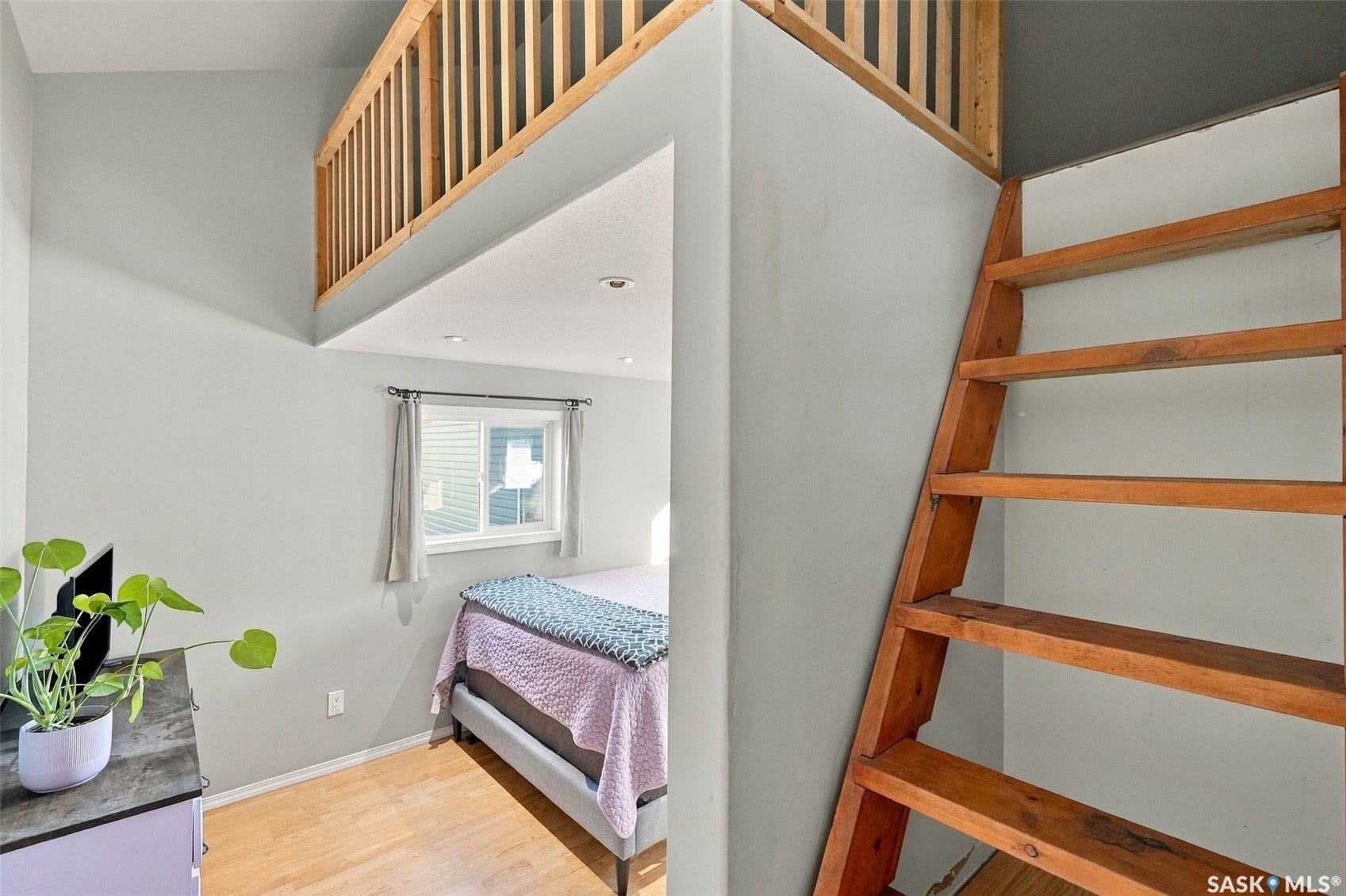 Wood finish flooring, natural wood ladder, and wood-railed loft area