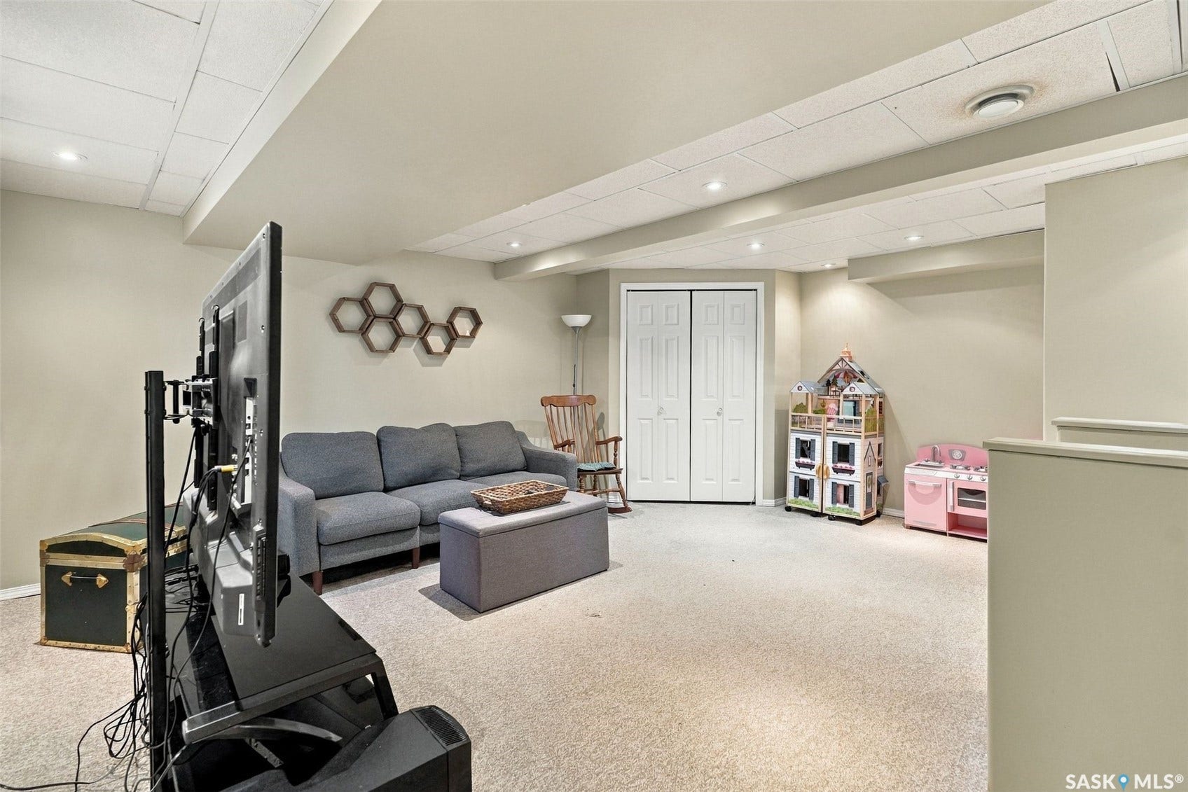 Recessed lighting illuminates the neutral-toned walls and light-colored carpeting