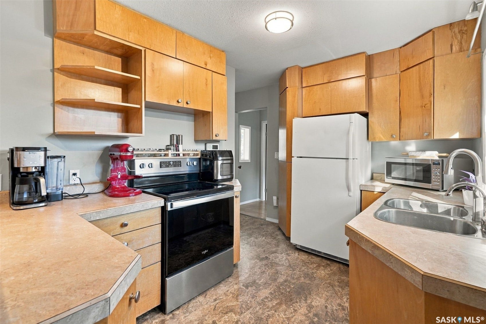 Wood cabinetry, stone-look countertops, and dual basin sink with a high-arch faucet