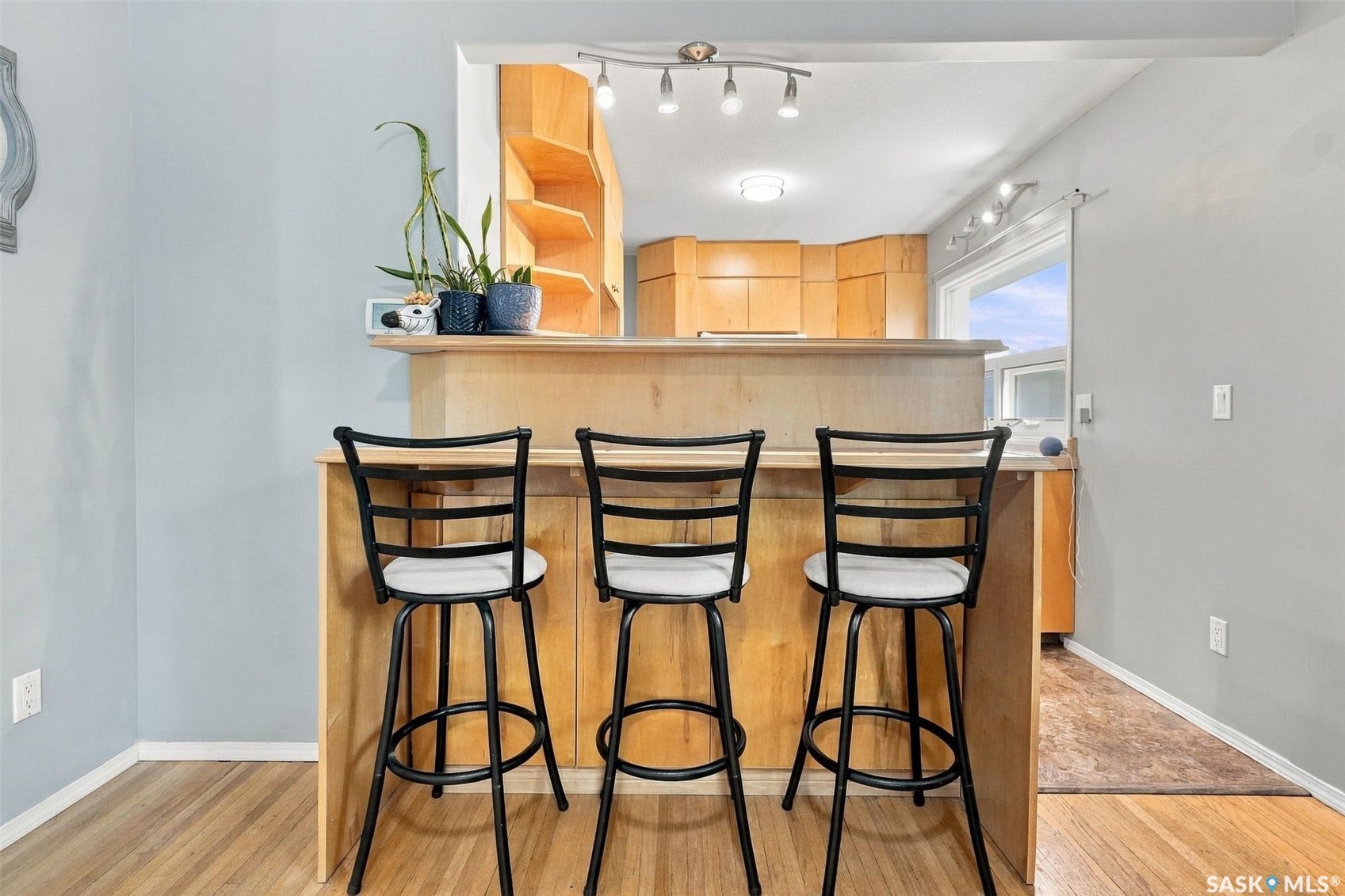 Breakfast bar with wood-finish base and light wood cabinetry