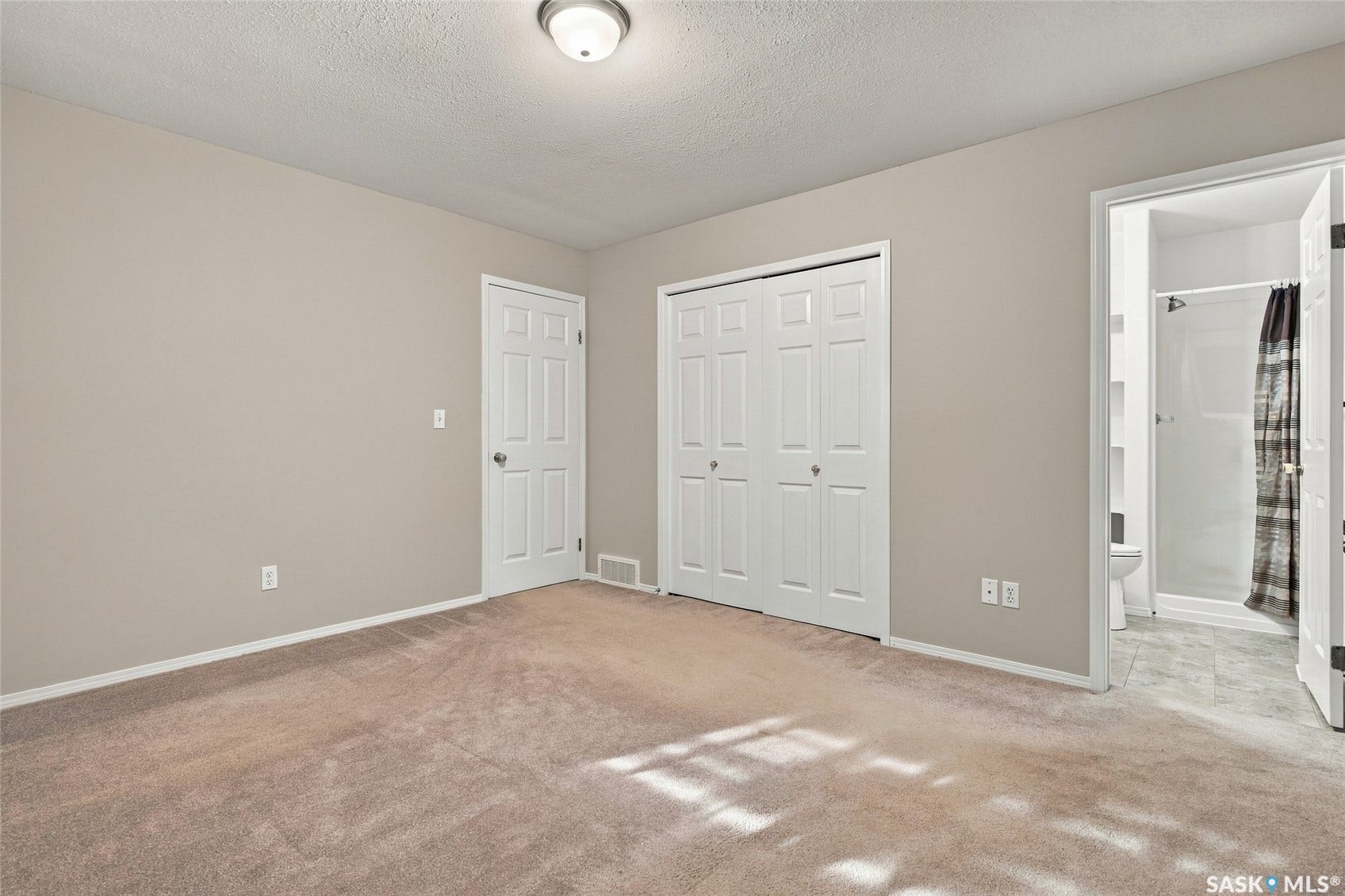 Neutral-toned walls featuring a ceiling-mounted light fixture, plush carpet flooring, a bifold closet, and a white six-panel door