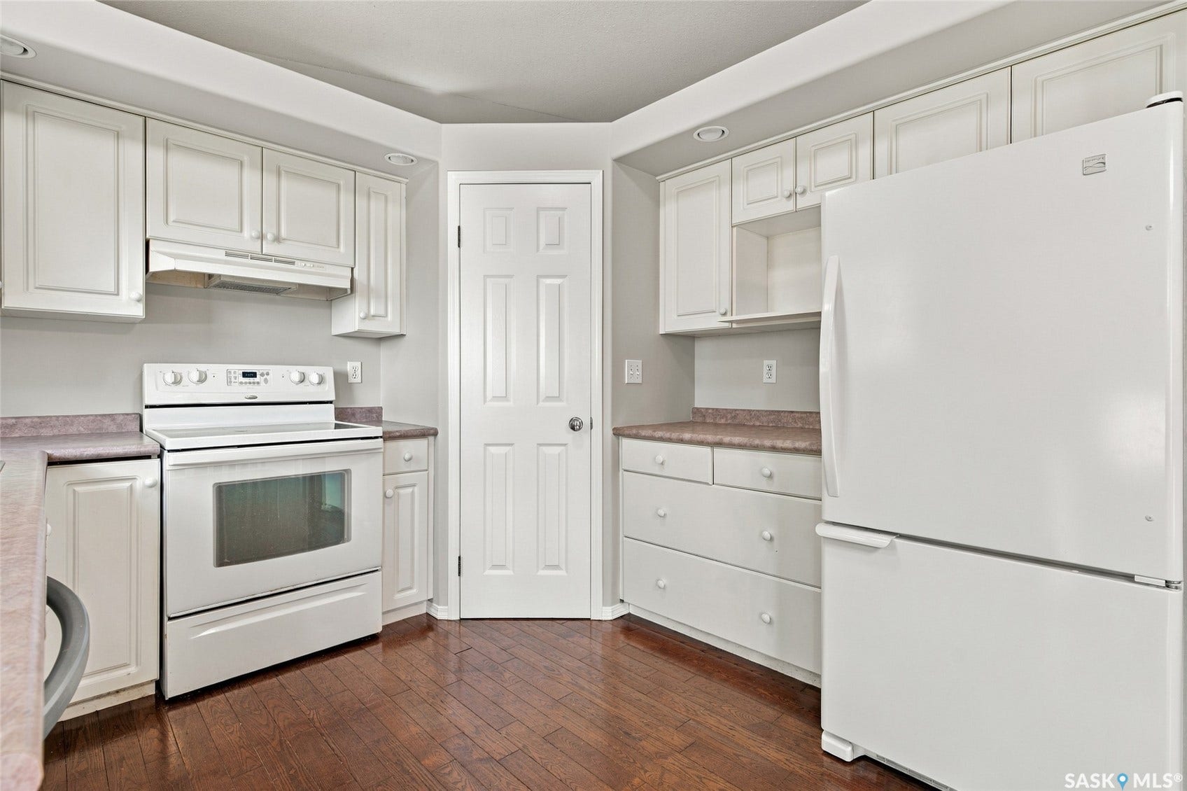Kitchen with wood-finish flooring, white cabinetry, and a full suite of white appliances