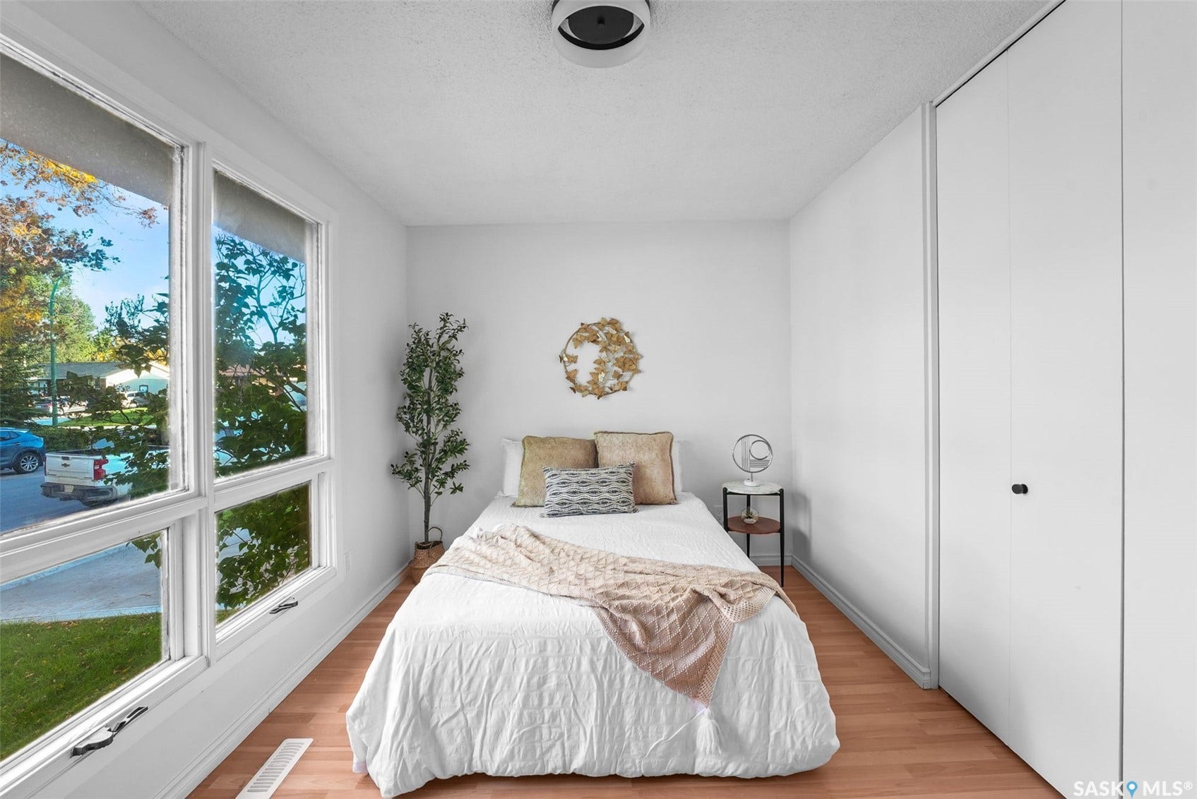 Wood-finish flooring, white walls, and a built-in closet with white doors