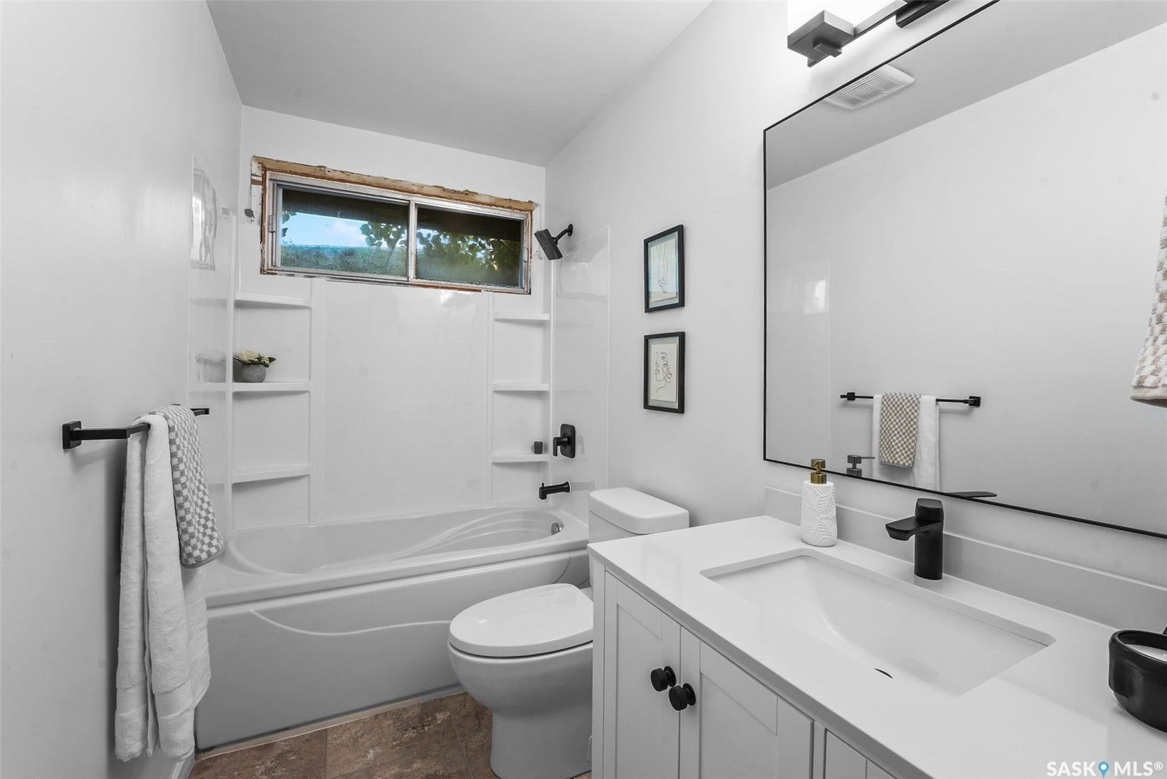 Vanity with a single basin, a dark finish faucet, and a large rectangular mirror