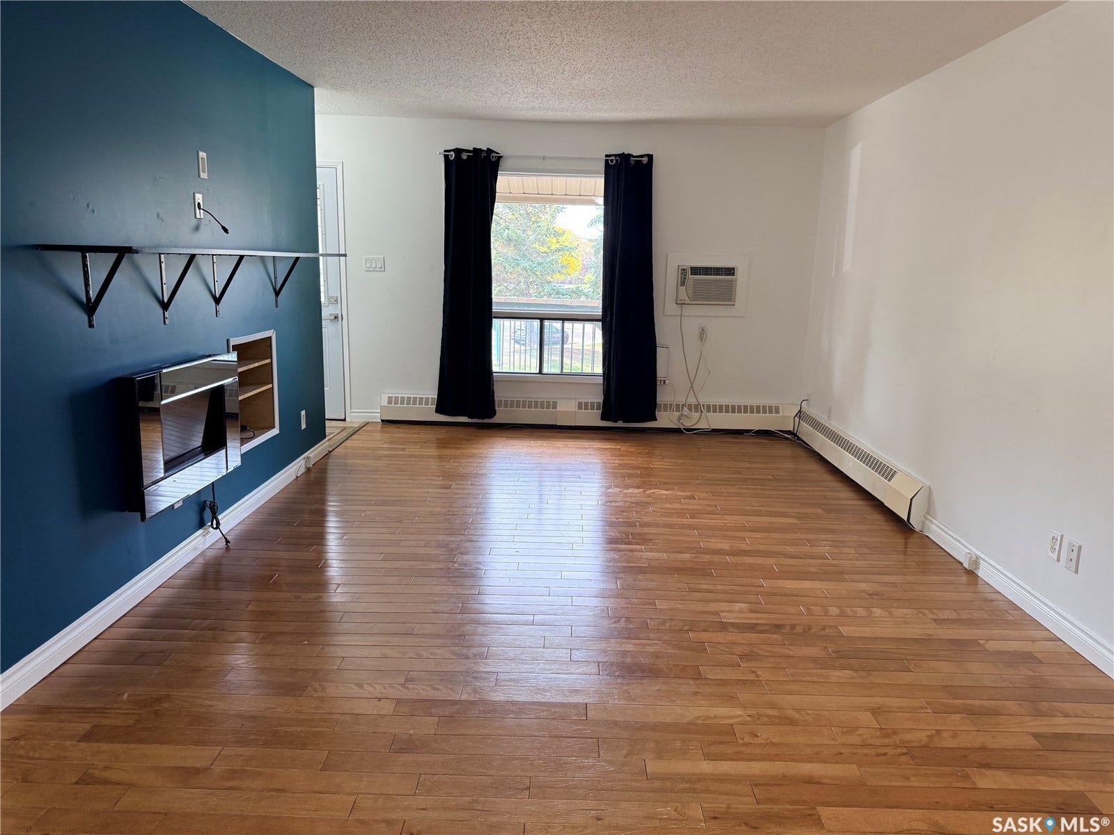 Wood-finish flooring throughout, with a feature wall and built-in shelving