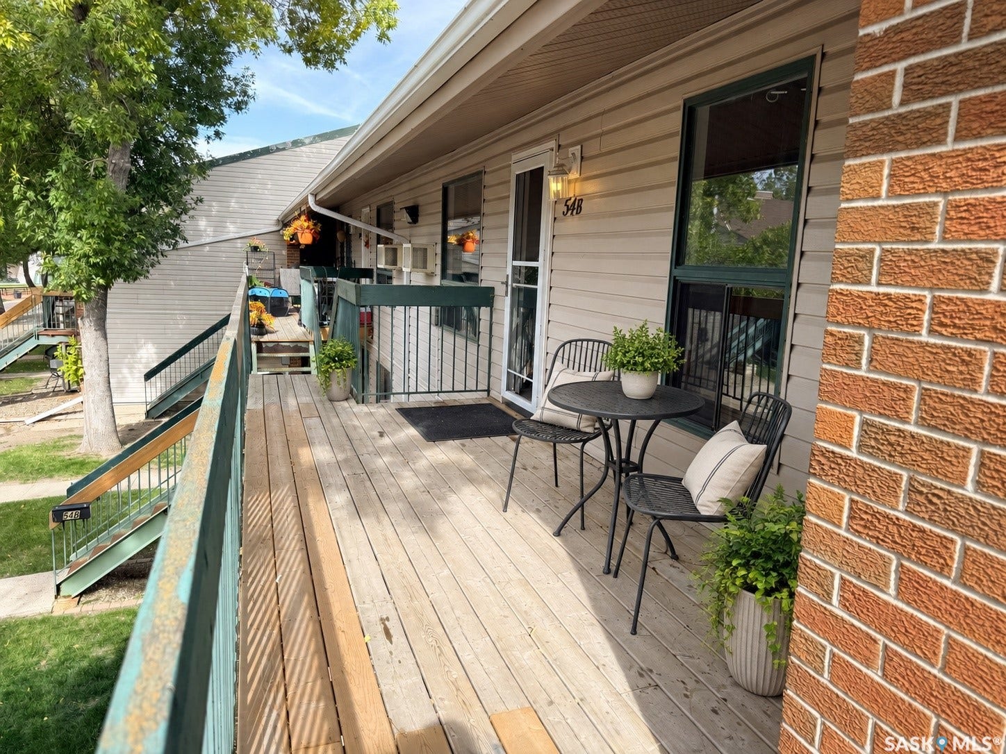 Private wood-finish deck with dark green railings