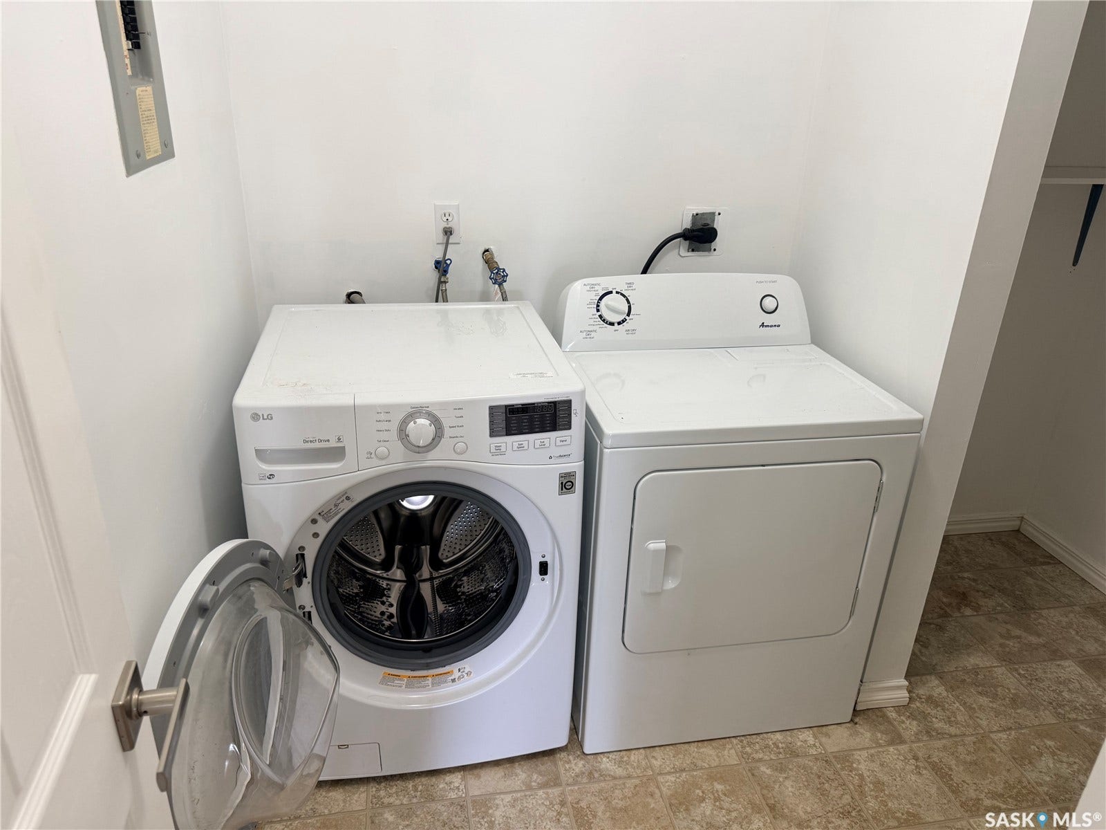 Laundry area with tile flooring and a front-loading washing machine