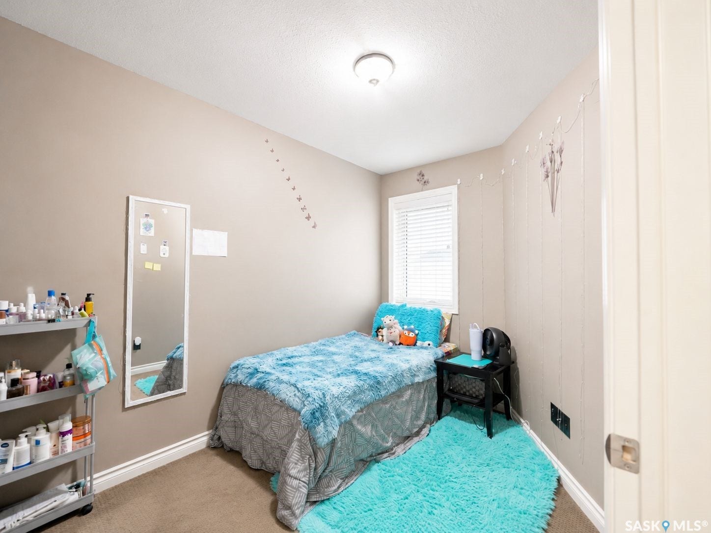 Neutral tone walls, recessed window with blinds, and ceiling-mounted light fixture