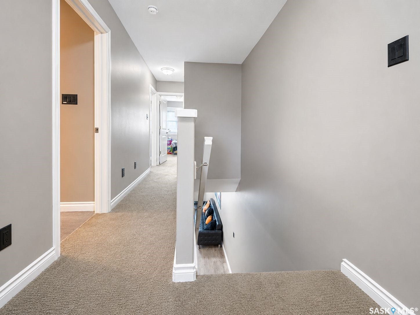Carpeted hallway with light gray walls, white trim, and recessed ceiling lights