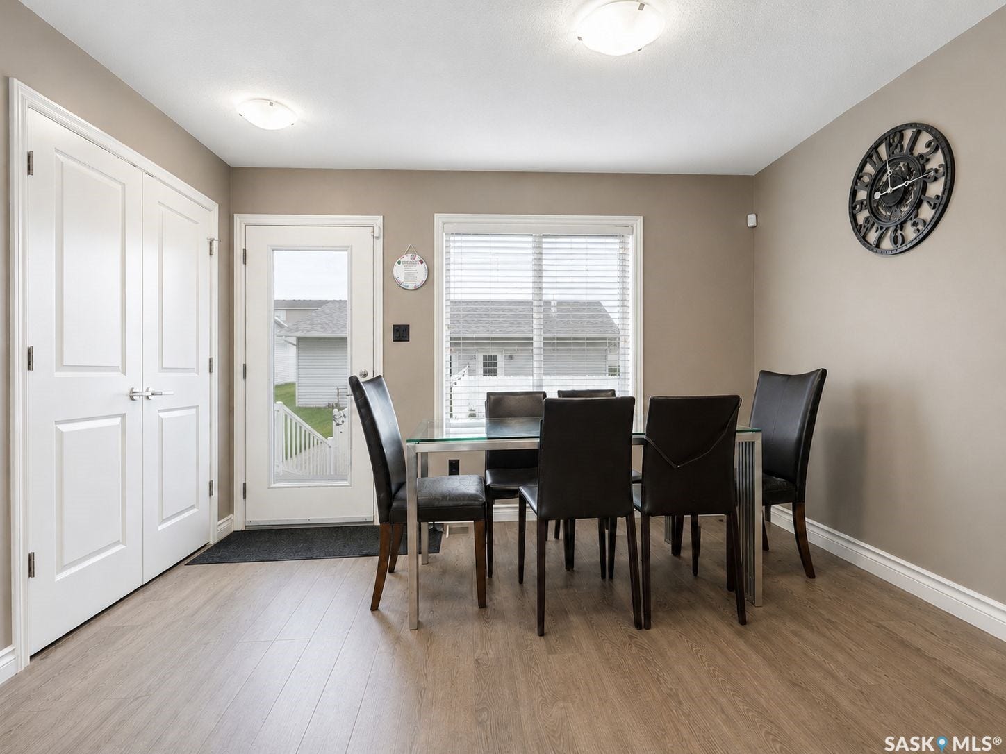 Wood-finish flooring, white trim, recessed lighting, double panel doors, and a glass-paned exterior door