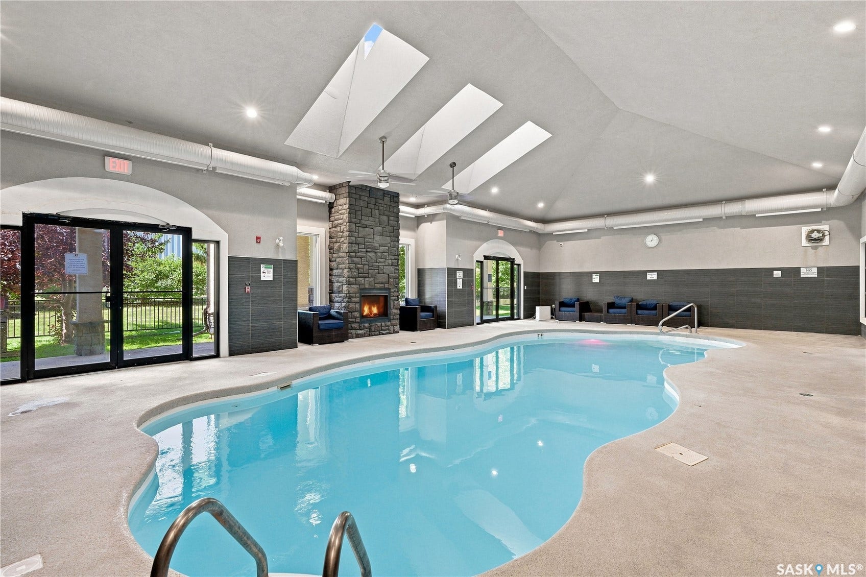 Indoor swimming pool with an irregular shape and metal handrails