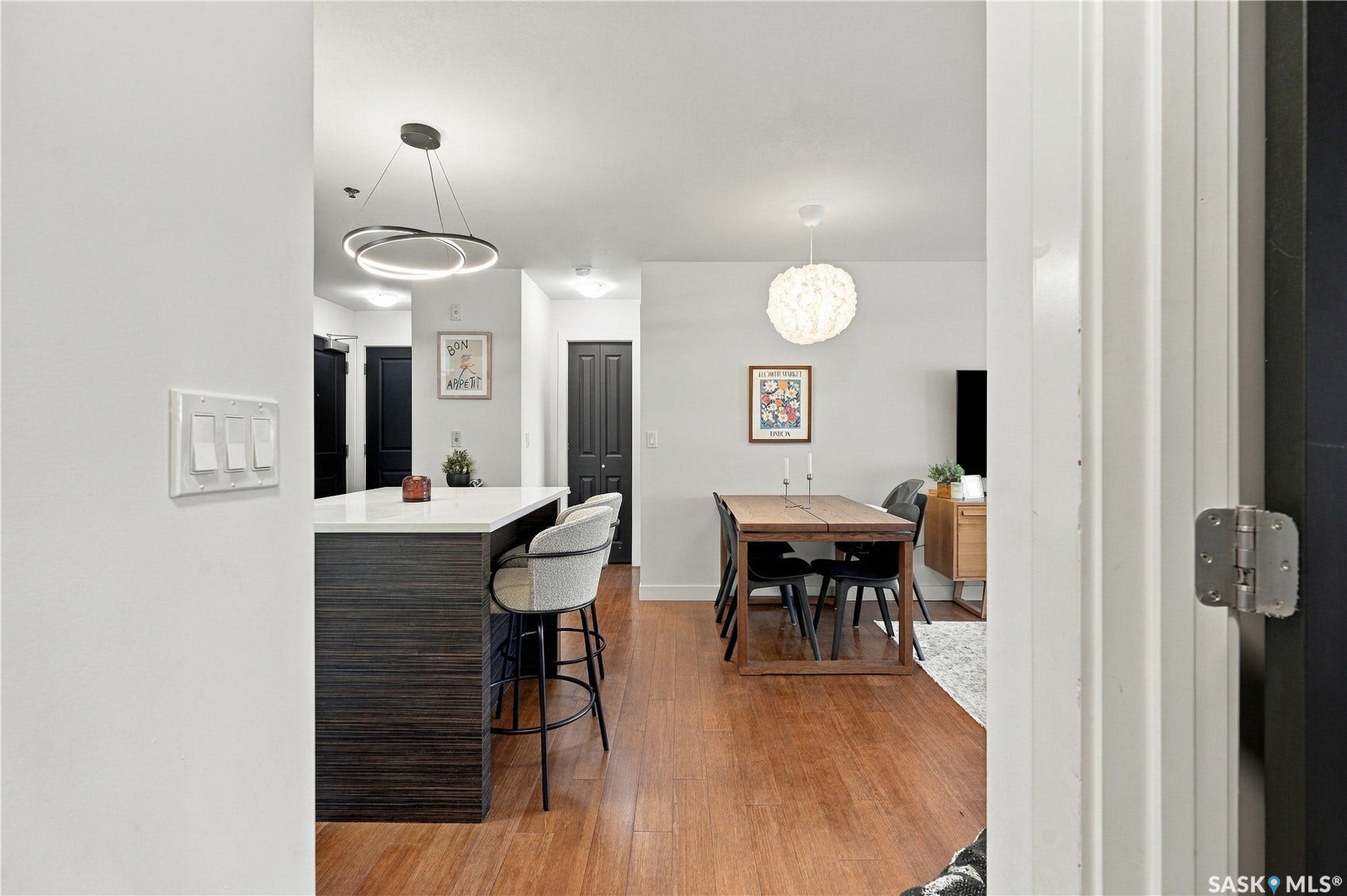 Hardwood-style flooring throughout, kitchen island with solid surface countertop, recessed lighting, and modern pendant lighting fixtures