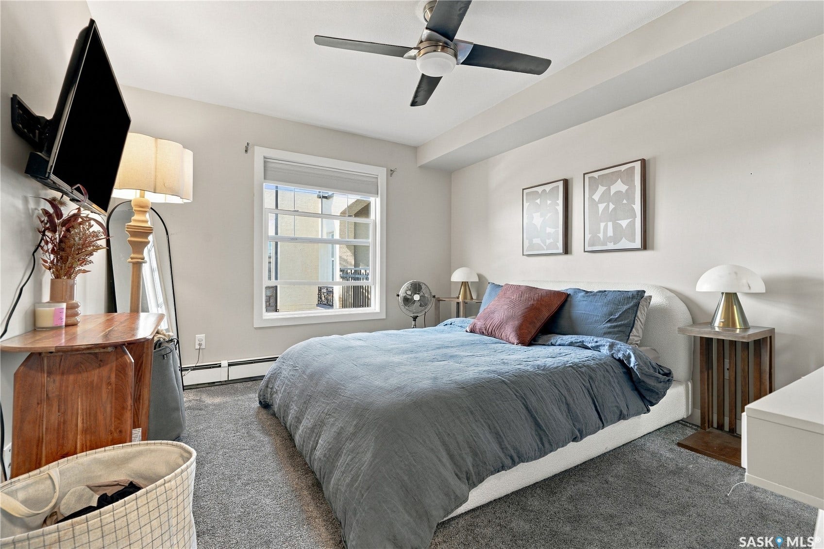 Light-colored walls, window with white trim, built-in ceiling fan, and carpeted flooring