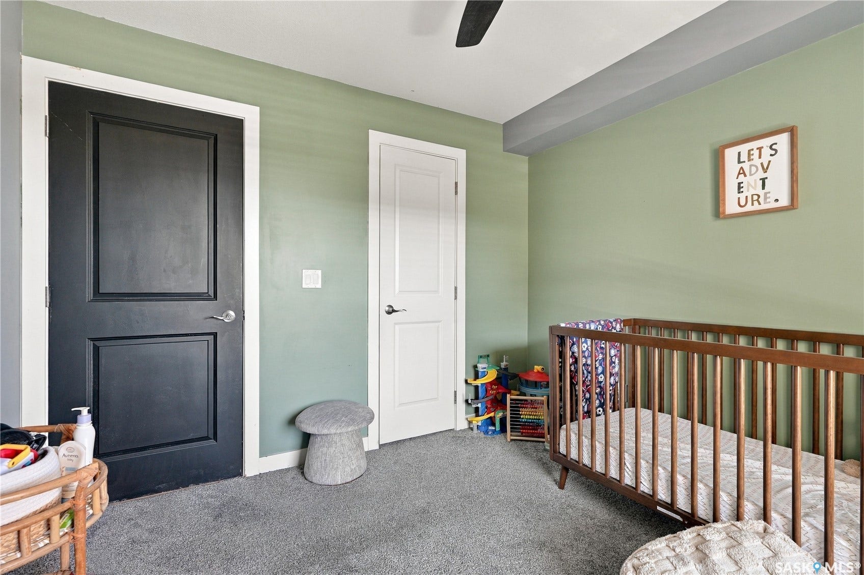 Plush gray carpeting, two-panel interior doors, light green wall paint, and a ceiling fan