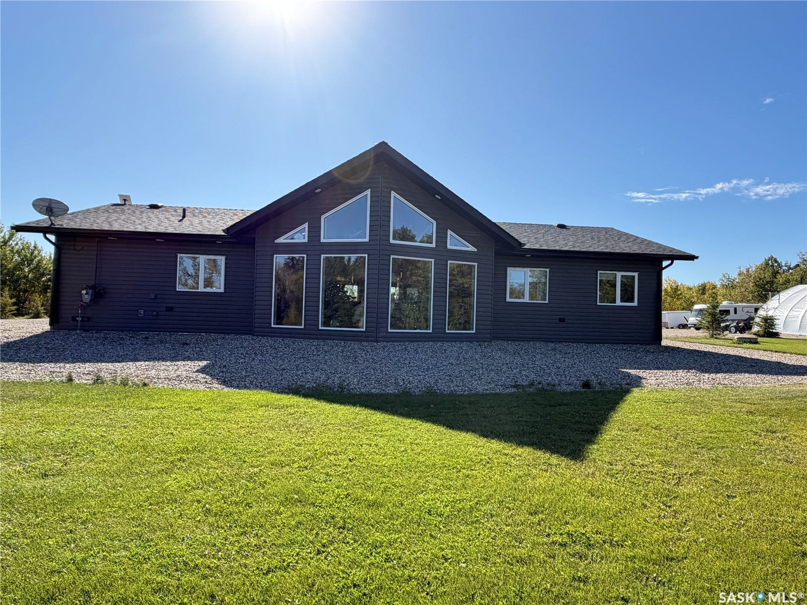 Modern architectural design featuring expansive windows, dark siding, and a gabled roofline