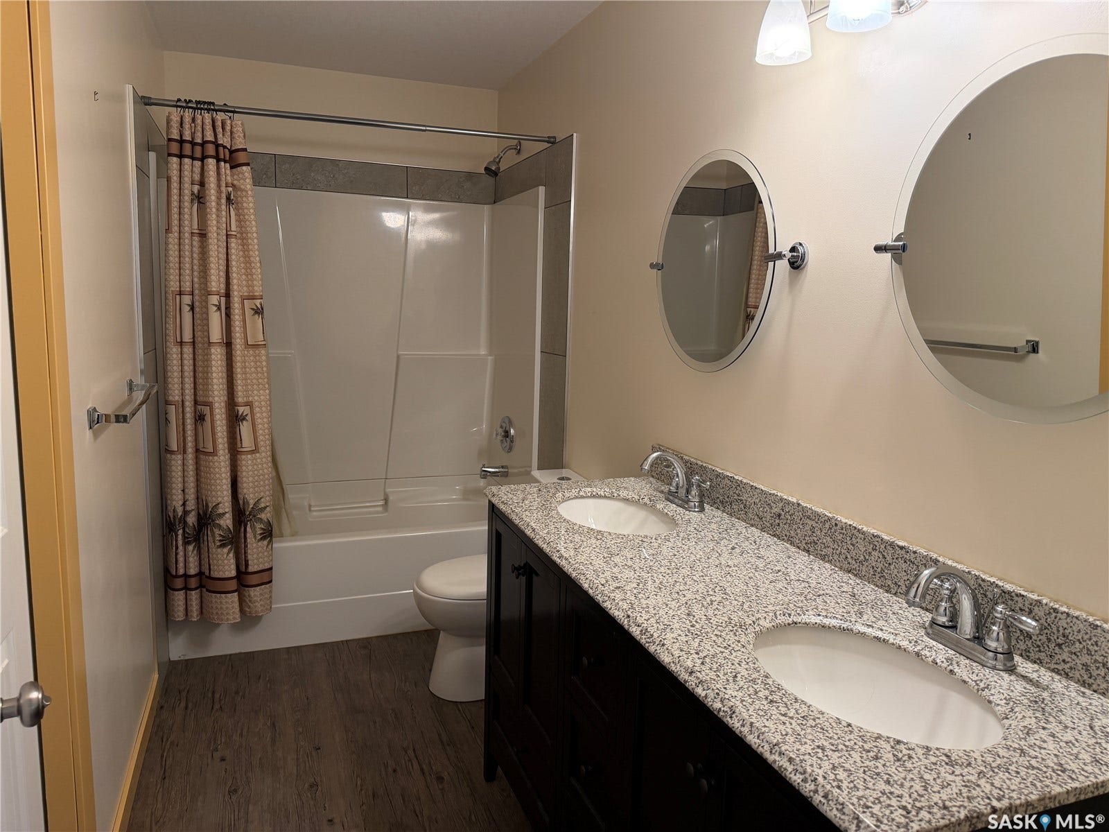 Dual vanity with integrated sinks, granite-style countertop, and wood-finish cabinetry