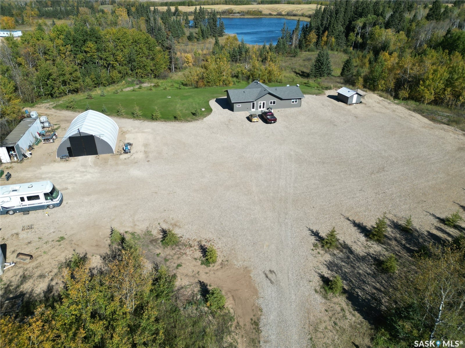 Spacious lot with a single-story residence, separate detached shed, and a large arched structure