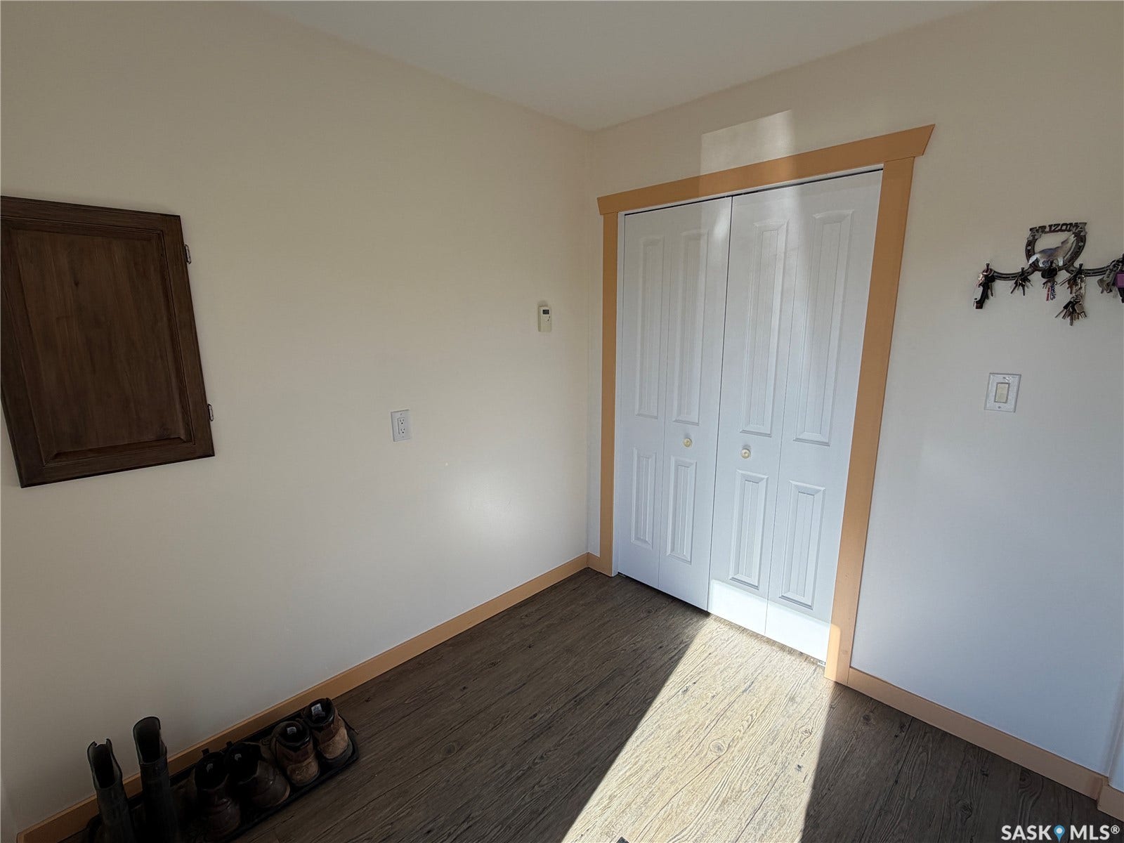 Wood-finish flooring, white walls, and a built-in wooden cabinet