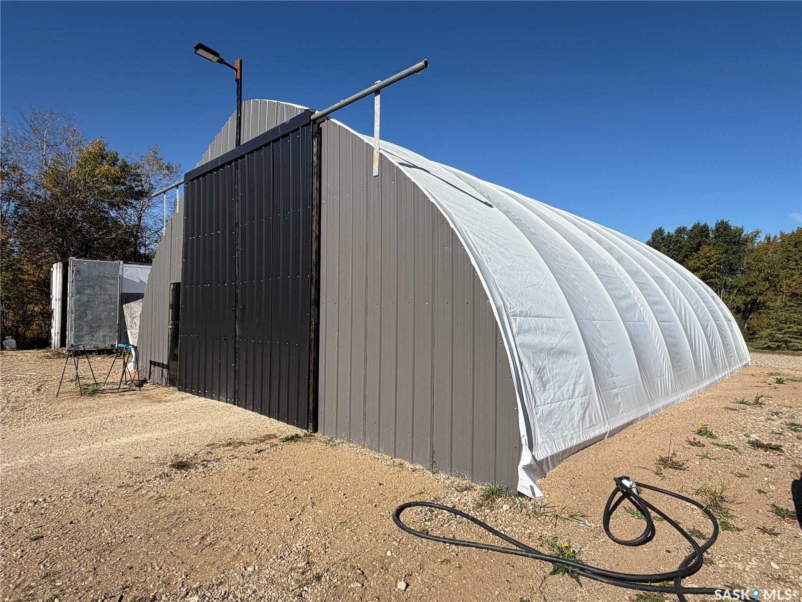 Metal-clad structure featuring a domed roof and a prominent dark vertical panel door