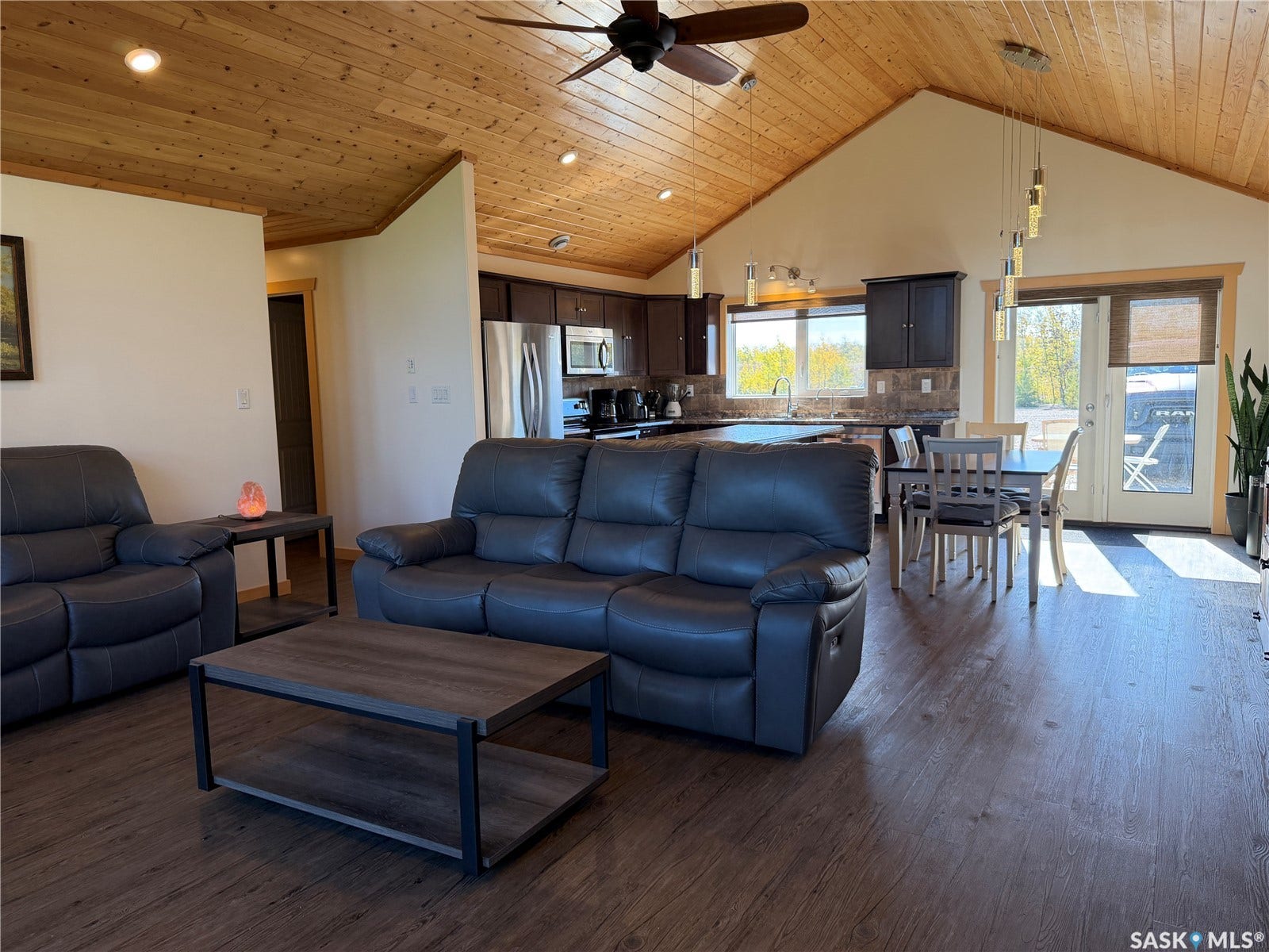 Vaulted wood-paneled ceiling with recessed lighting and a ceiling fan, wood-finish flooring, dark wood cabinetry, and stainless steel appliances