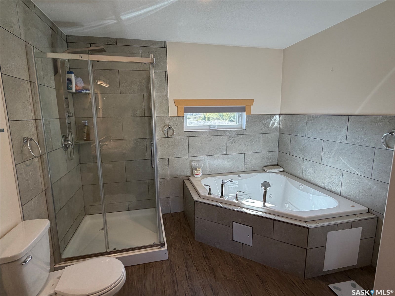 Walk-in shower with clear glass enclosure and tile surround