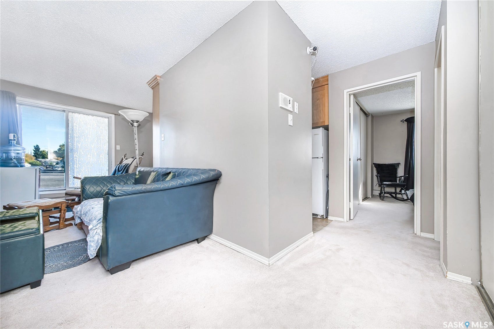 Sliding glass door, light-toned wall paint, neutral carpeting, and a built-in wood-finish cabinet