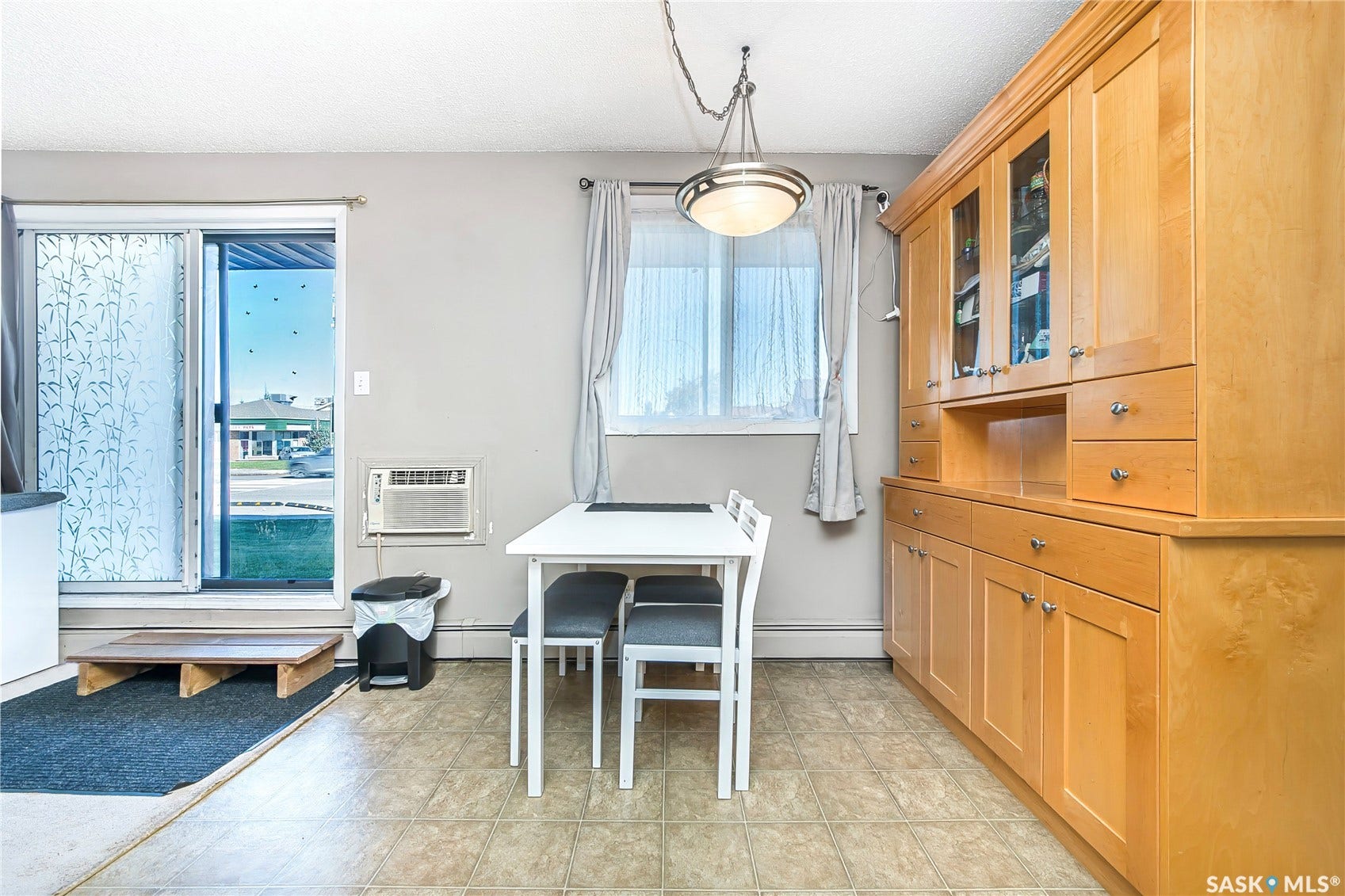 Built-in wood cabinetry with glass-front uppers, a sliding glass door, and vinyl flooring