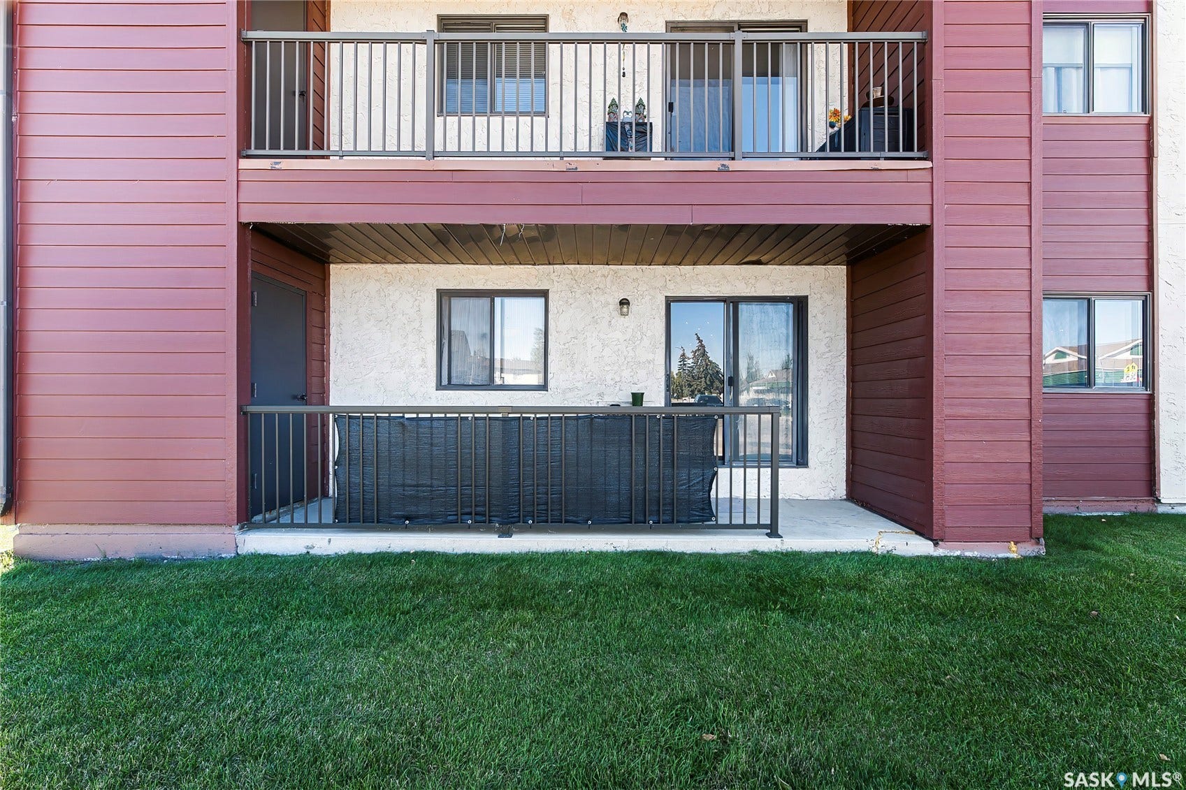 Ground-level patio with concrete slab and dark metal railings