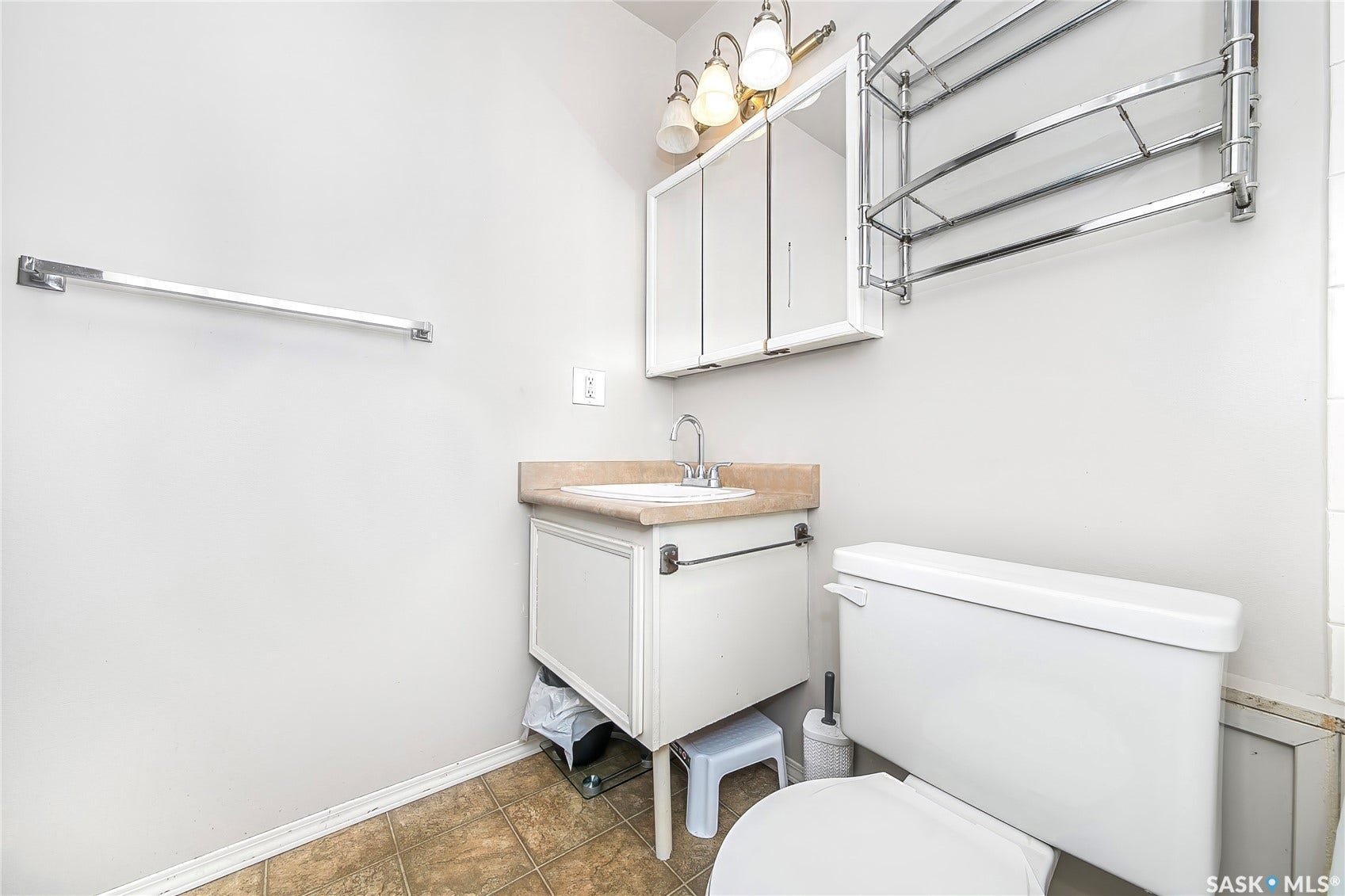 Compact bathroom with a white vanity, integrated sink, and light-colored countertop