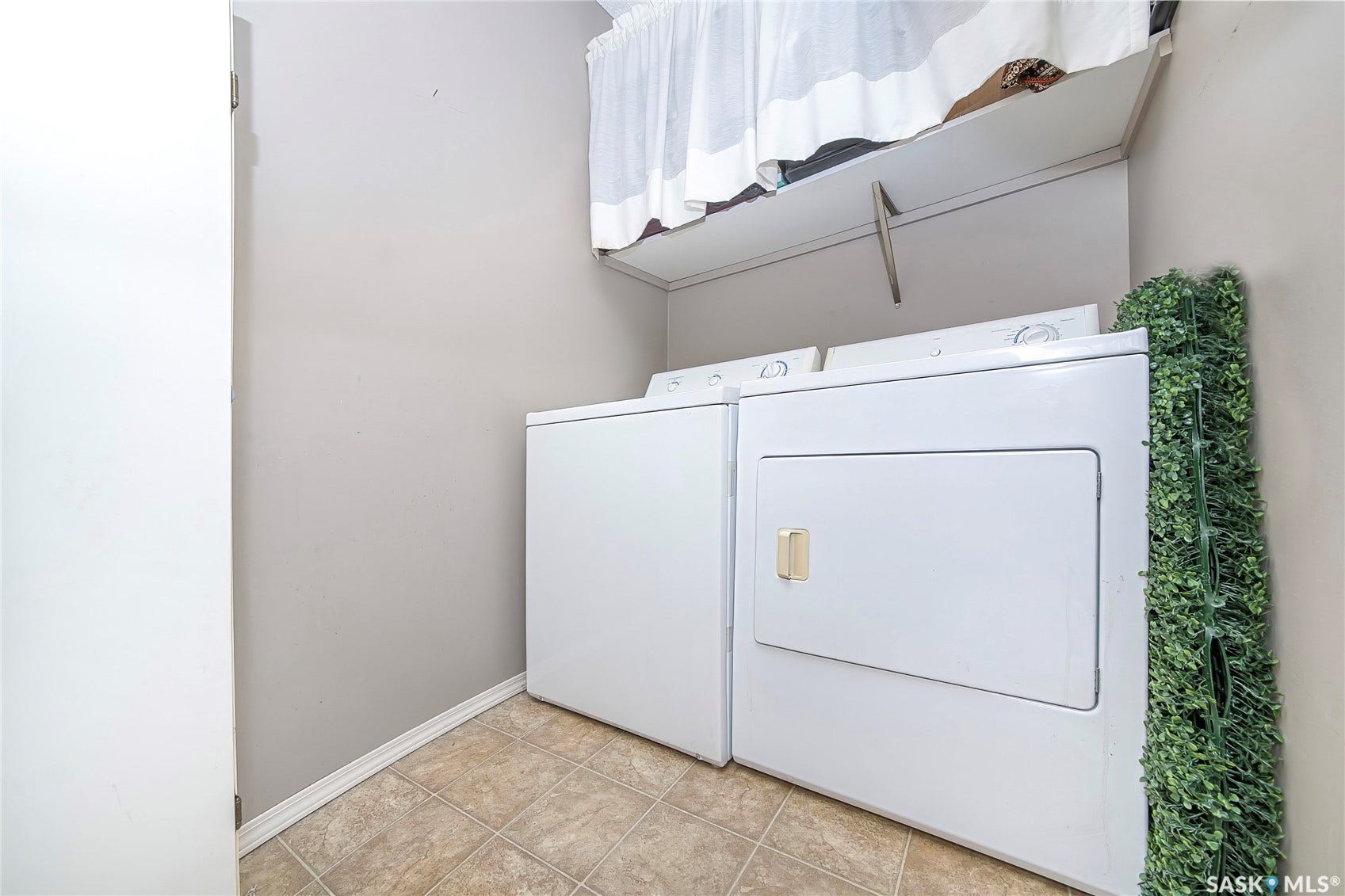 Laundry area featuring a tiled floor and a built-in shelf