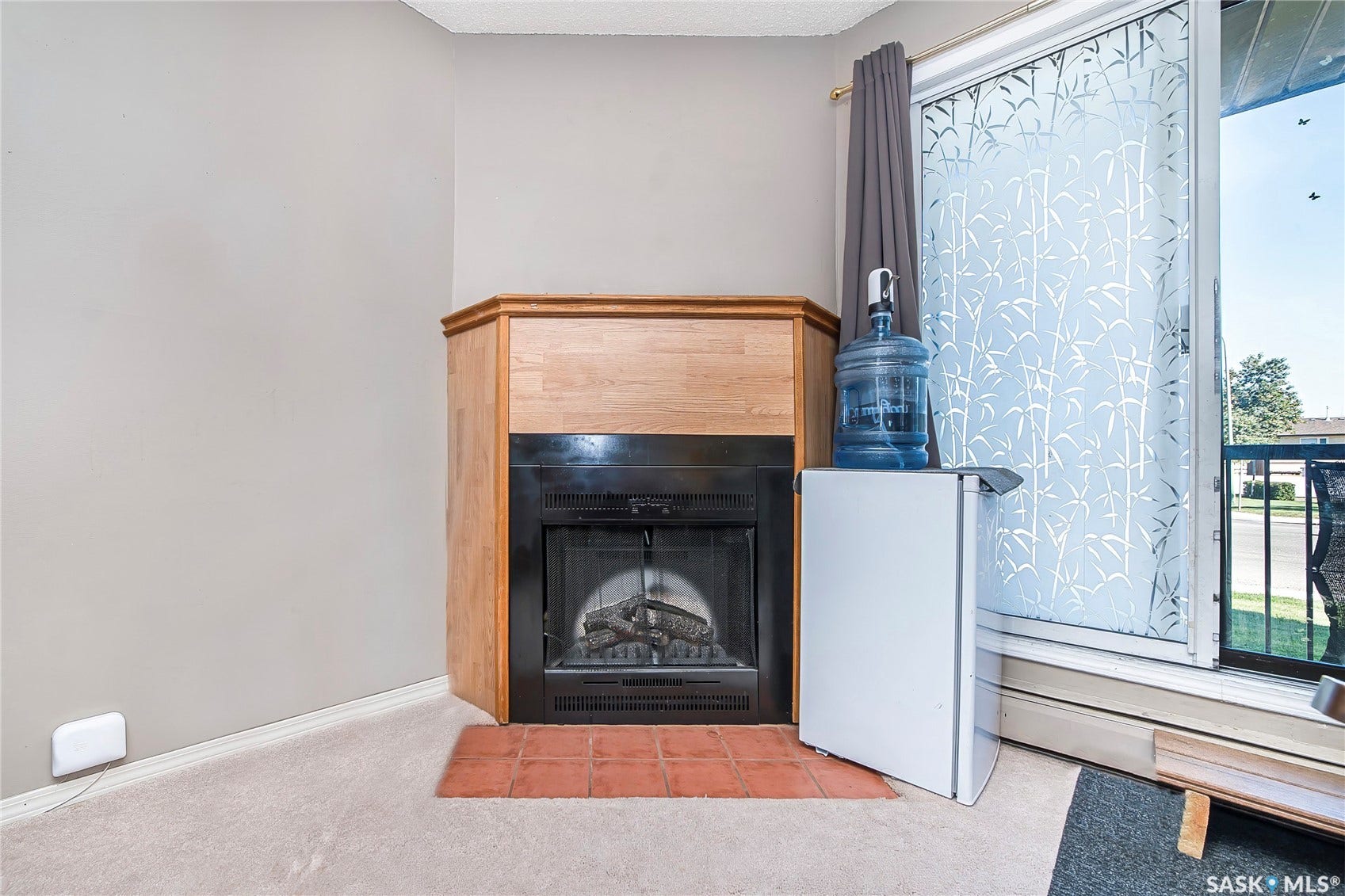 Corner fireplace with a wood-finish mantel and a tile hearth