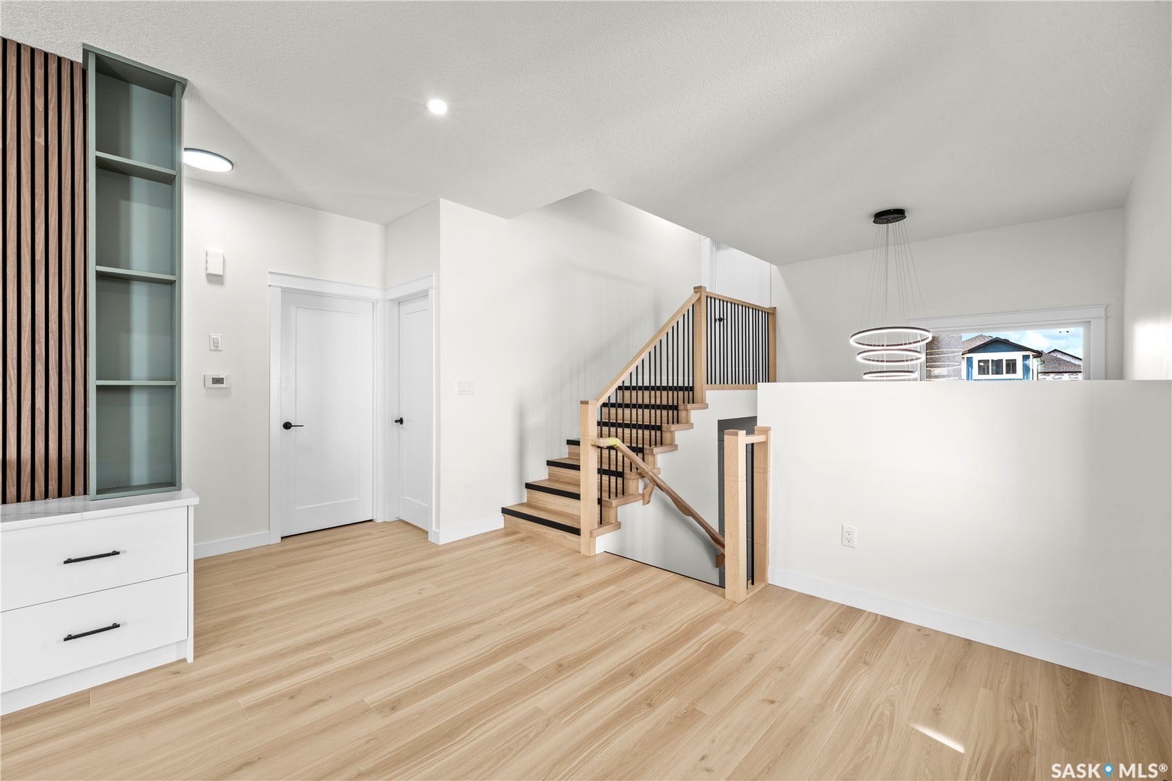 Open-concept living space with light wood-finish flooring