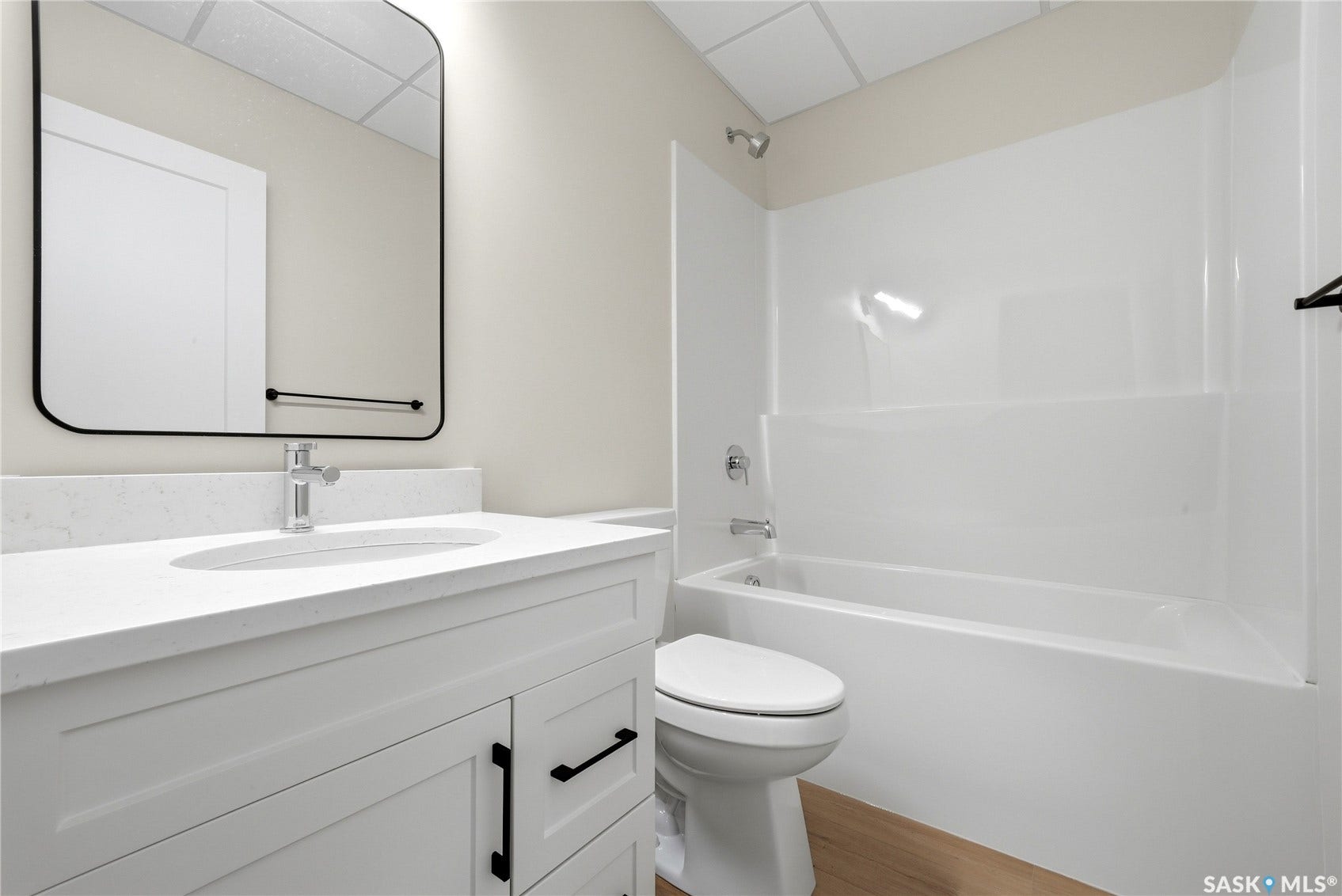 White shaker-style vanity with a light-colored countertop, undermount sink, and chrome faucet