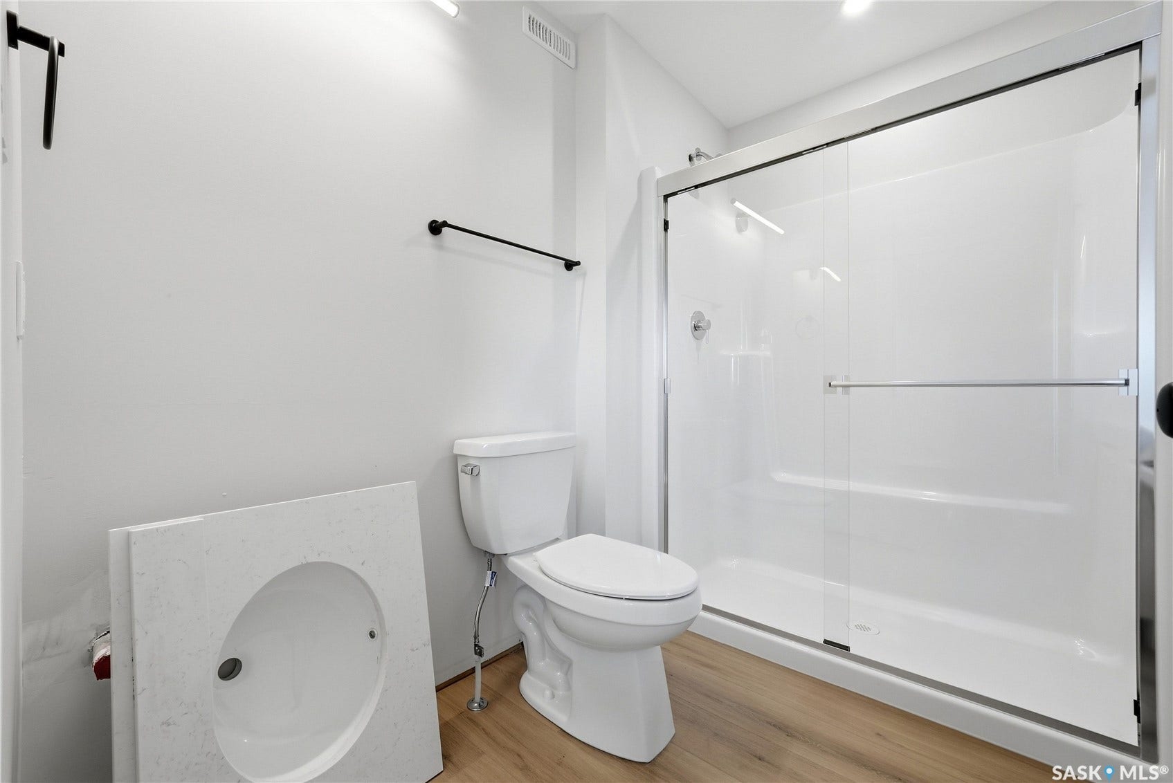 White shower enclosure with sliding glass door and chrome hardware